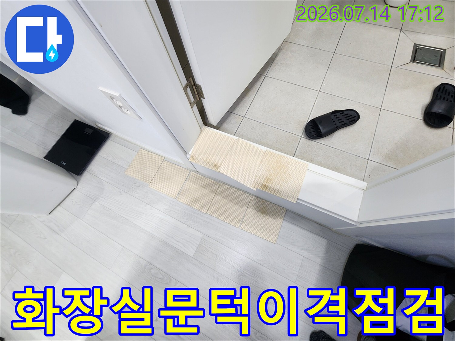 화장실 문턱과 바닥 타일 사이의 틈새를 점검하는 모습