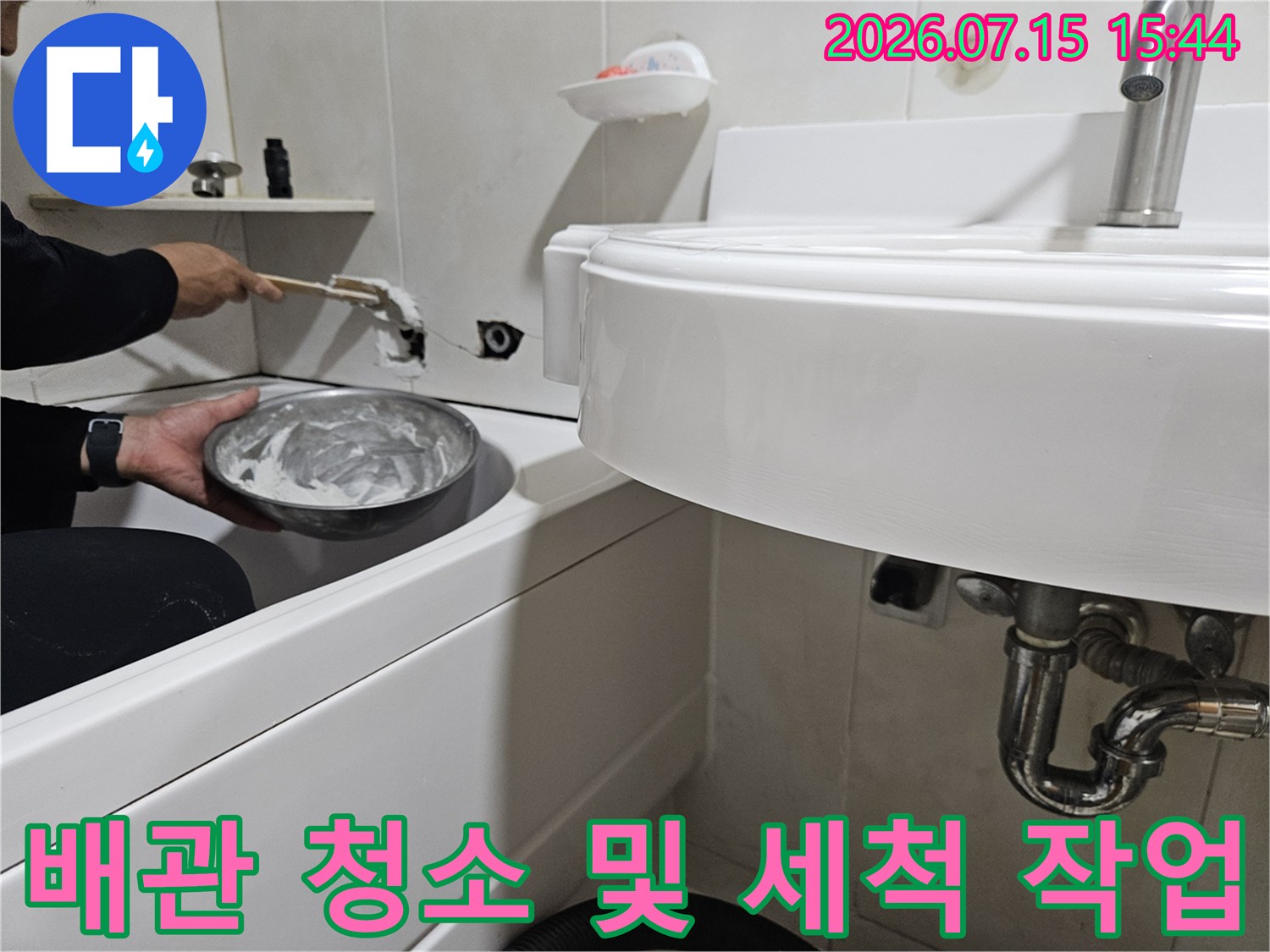 세면대 하부 배관을 붓으로 세척하며 누수 지점을 찾는 장면