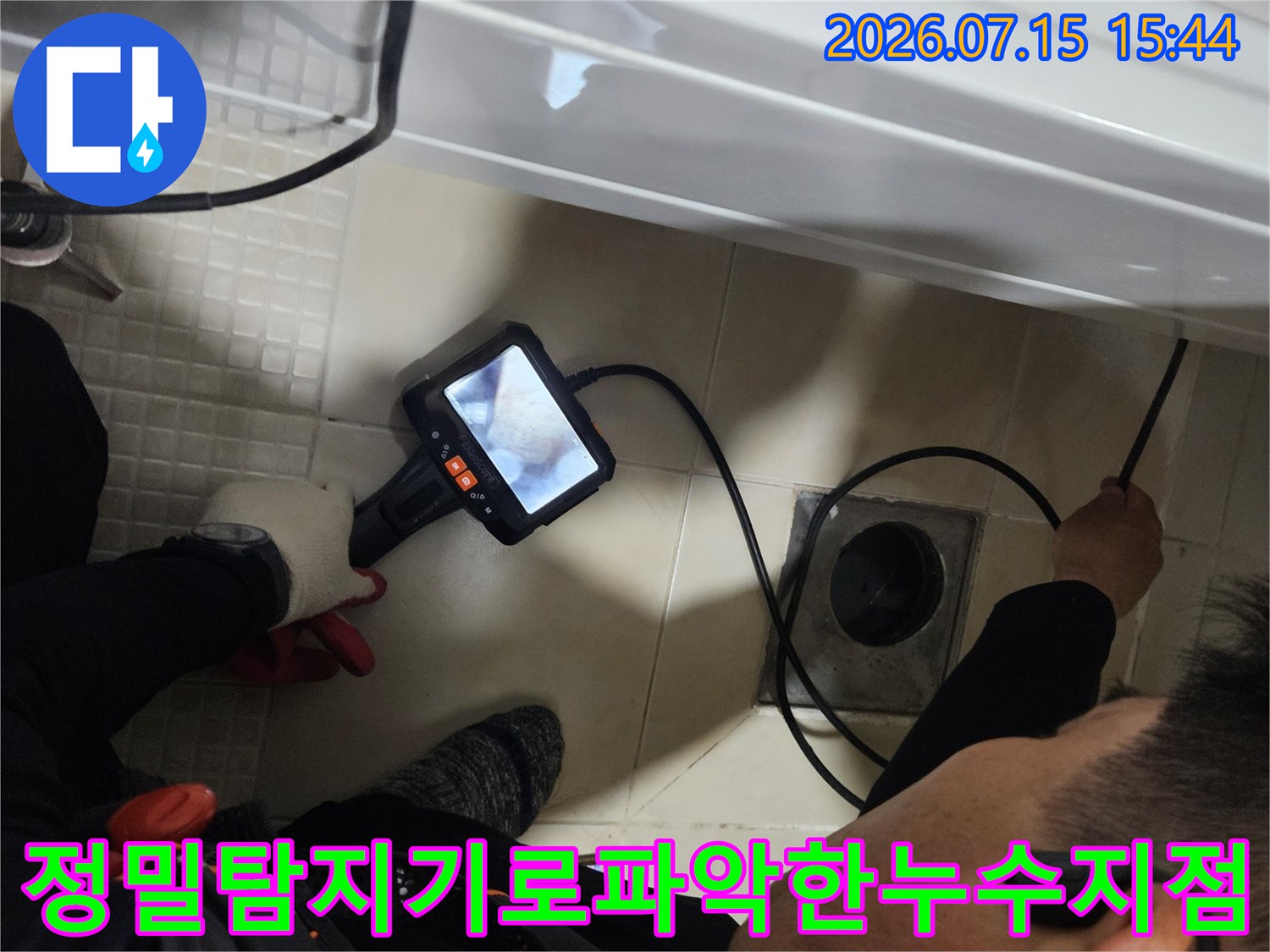 세면대 하부 배관의 누수 위치를 청음식 장비로 정교하게 파악하고 있는 모습