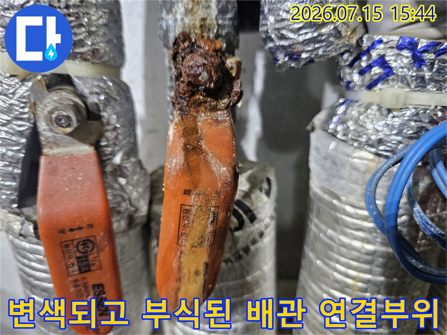 오래되어 변색이 심한 노란색 배관과 금속체 연결 부품의 상세 샷
