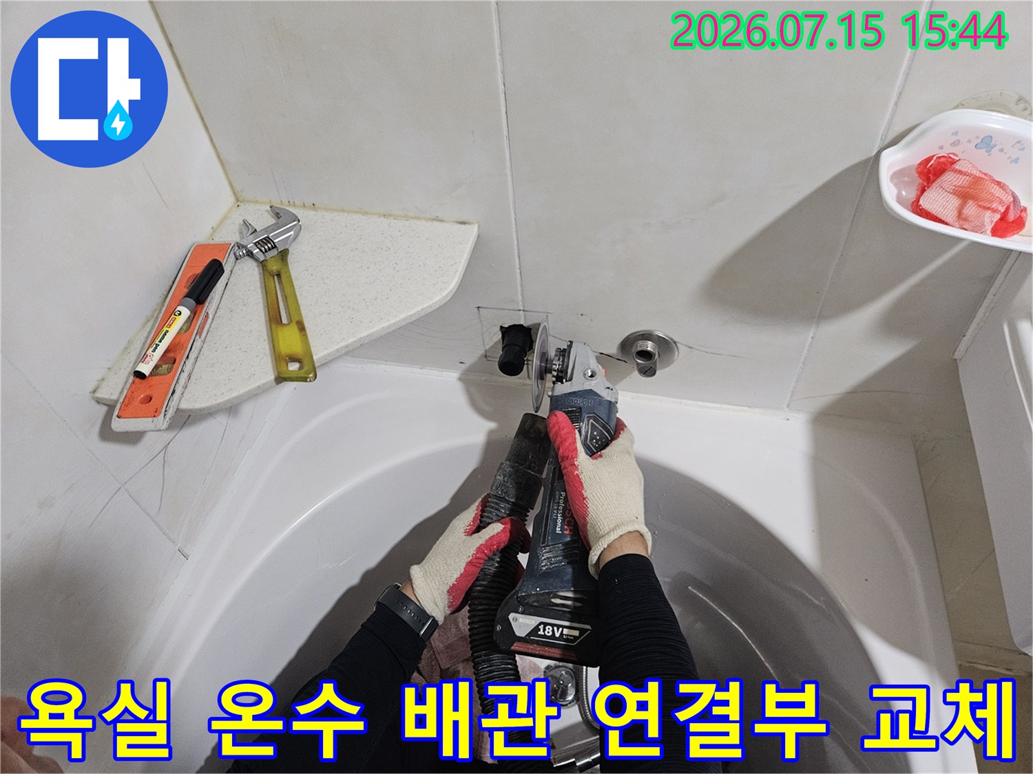 장비를 사용하여 세면대 하부의 노후된 온수 배관 부품을 새것으로 교체하는 장면