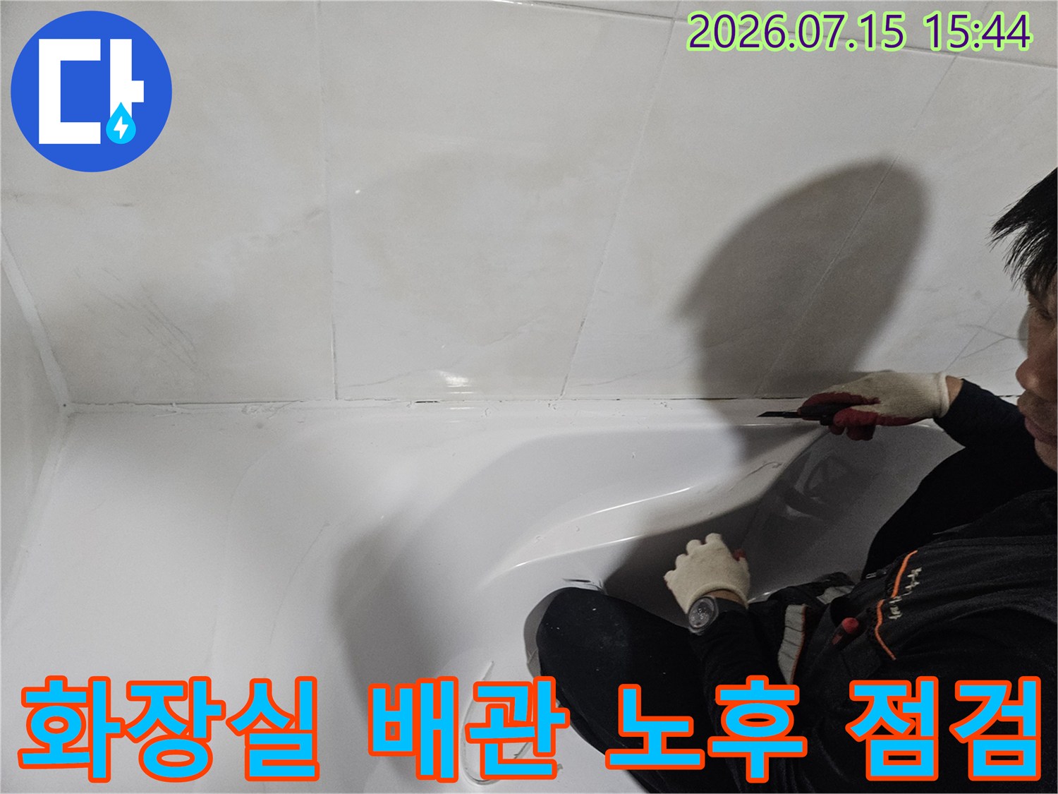 전문가가 세면대 밑쪽의 배관 시스템을 꼼꼼하게 검수하고 있는 모습