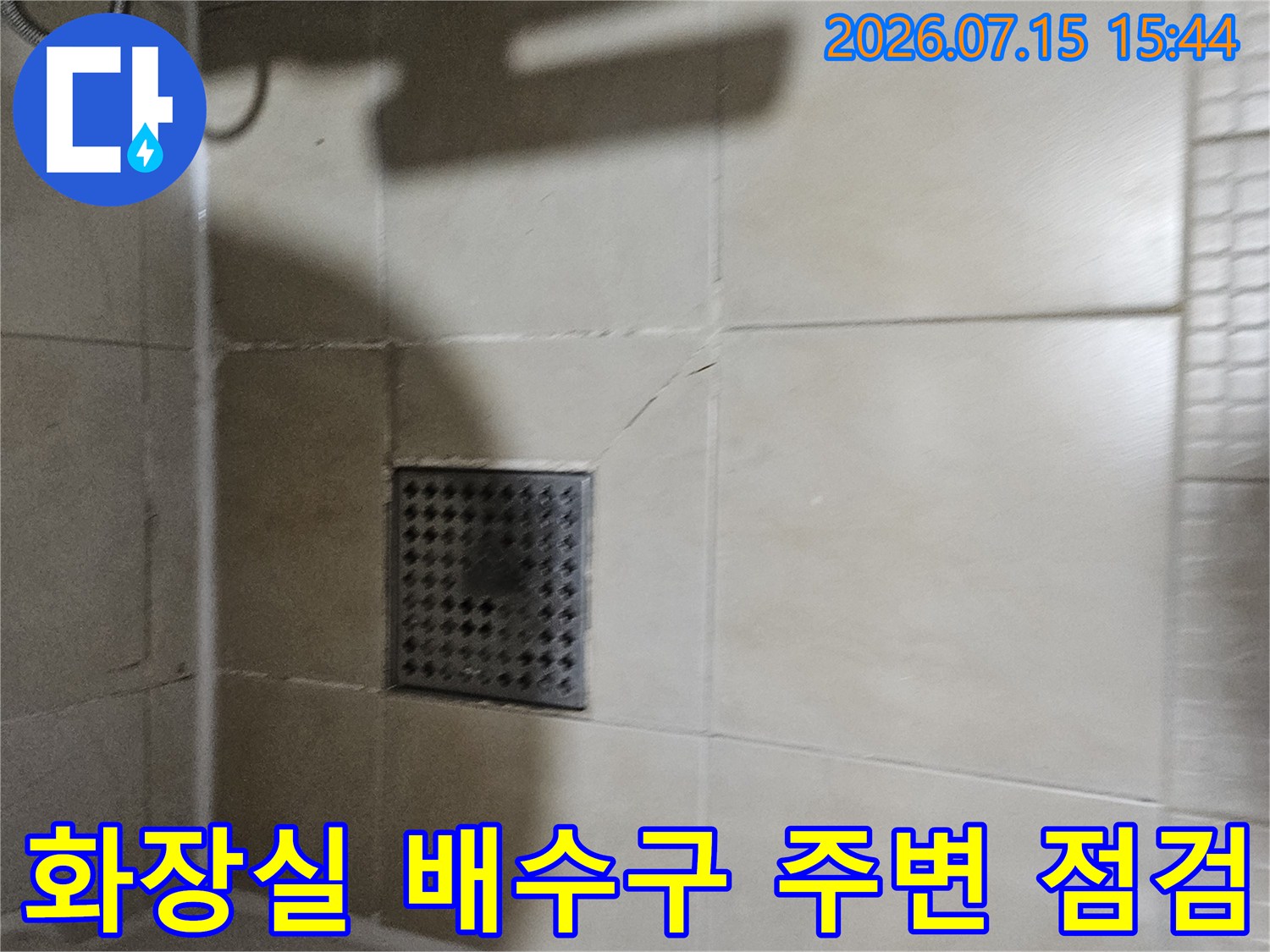 타일 바닥 위에 설치된 배수구와 주변을 확인하는 누수 진단 사진