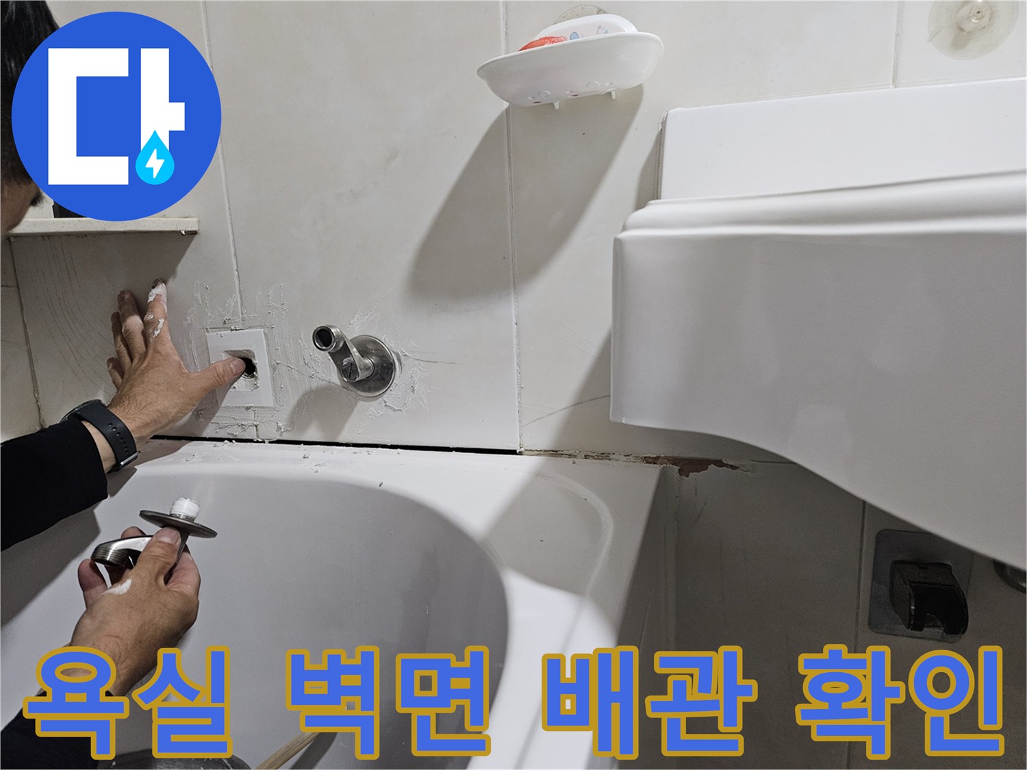 화장실 벽면 타일 사이로 노출된 누수 의심 배관