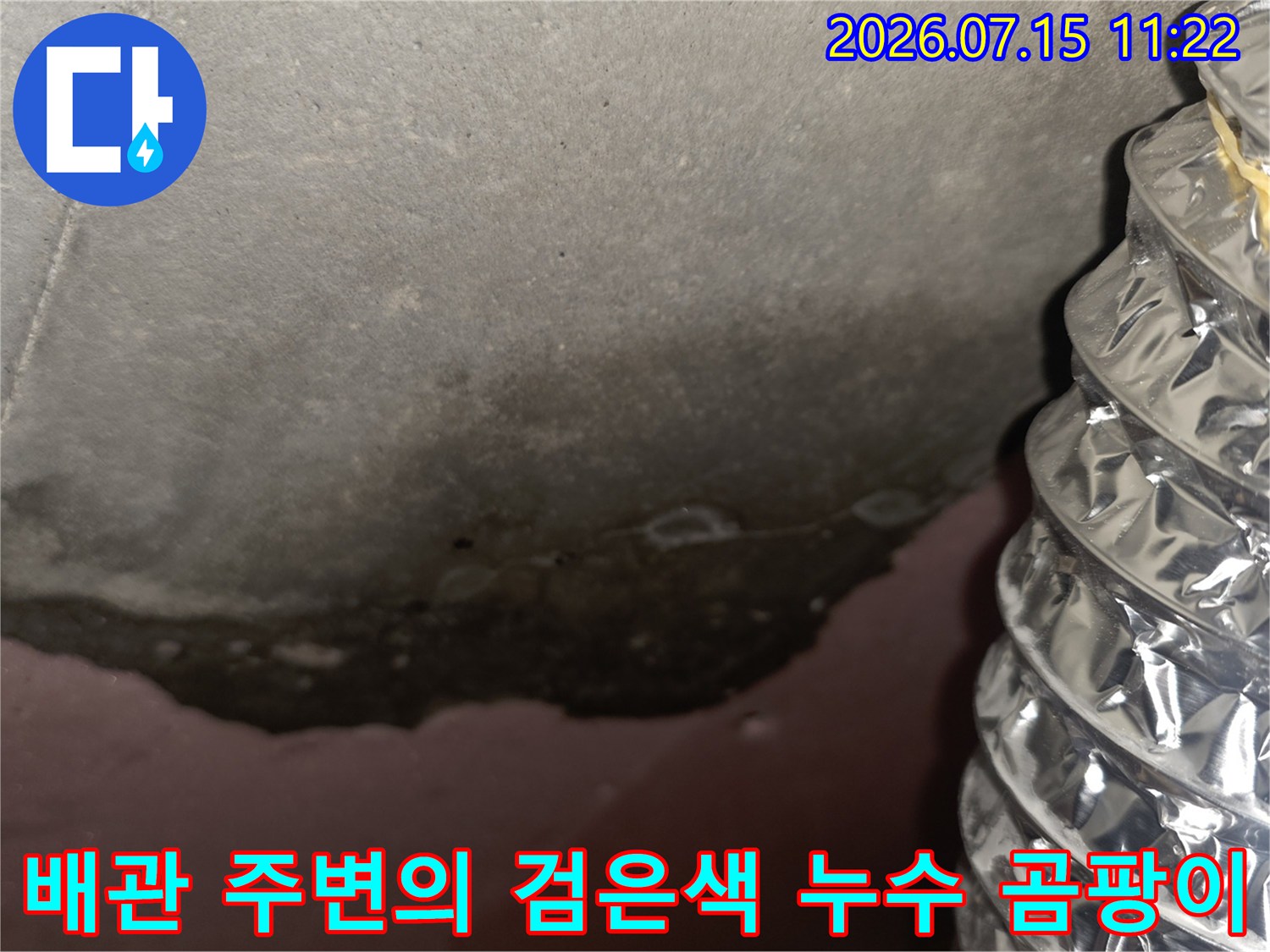 천장에 설치된 은색 자바라 관과 그 좌측으로 넓게 퍼진 검은 물자국 사진