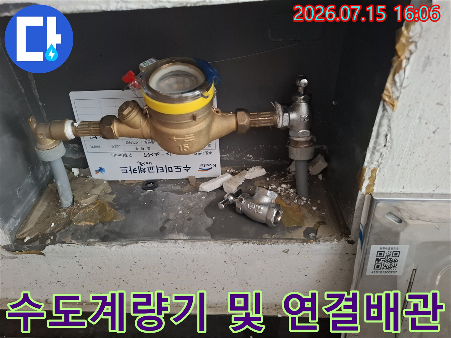 회색 함 내부에 설치된 황동색 수도 계량기와 연결 배관-부속품들이 보이는 모습