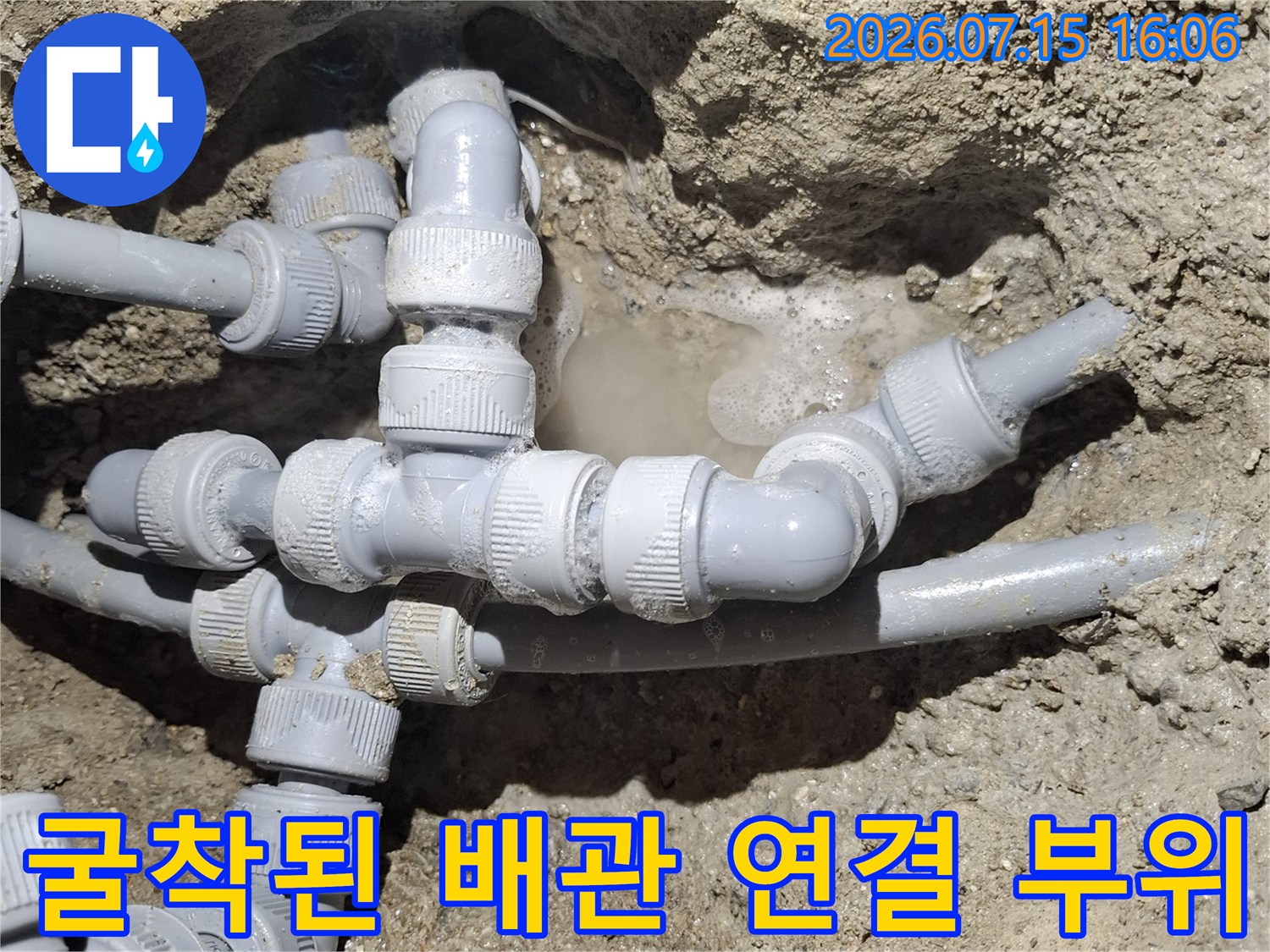 흙 속에 매립되어 있던 회색 플라스틱 수도관의 복잡한 분기점 모습
