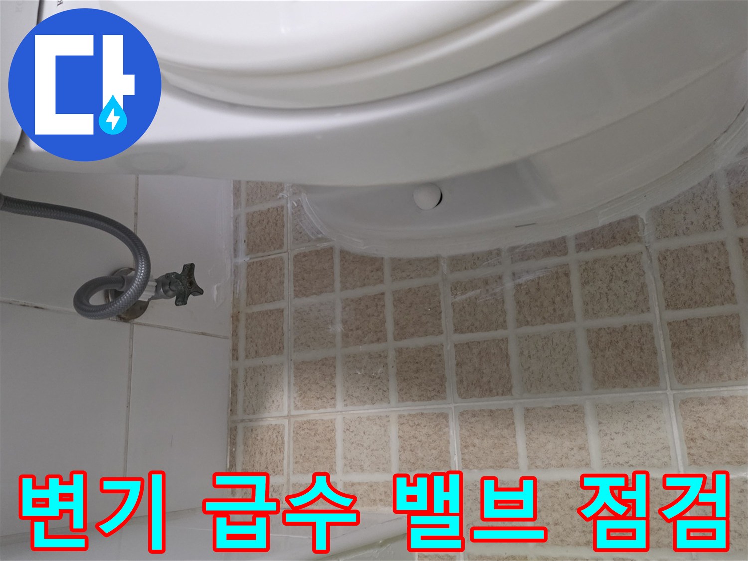 변기 옆 앵글밸브와 타일 바닥의 근접 촬영