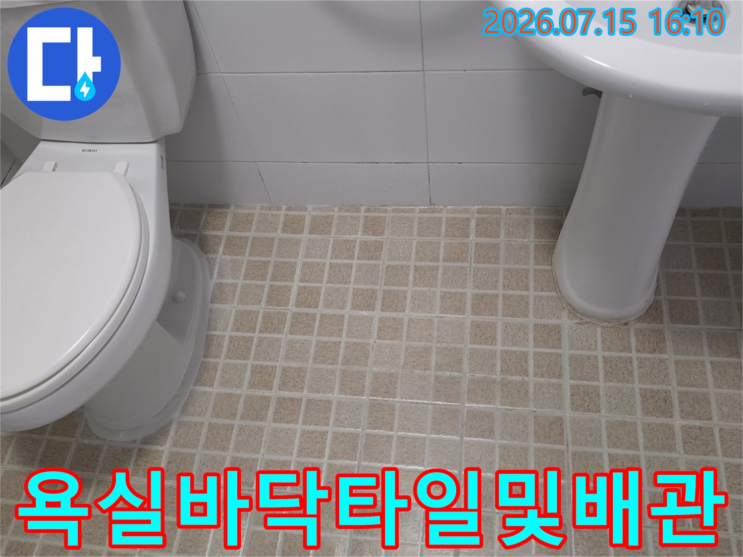세면대와 양변기가 설치된 화장실 바닥 타일과 배관망
