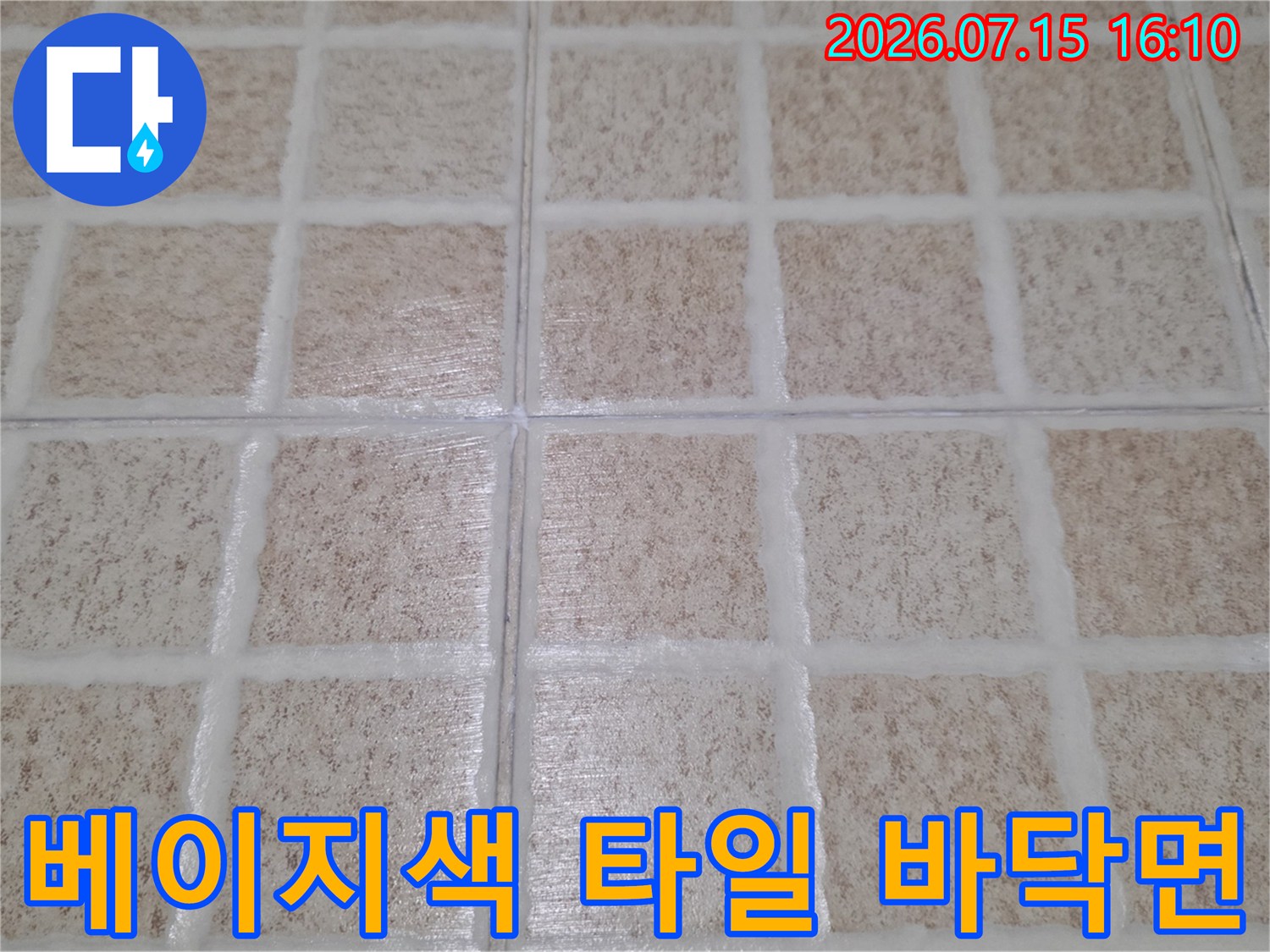 화장실 내부의 베이지톤 바닥 타일과 흰색 메지라인 사진