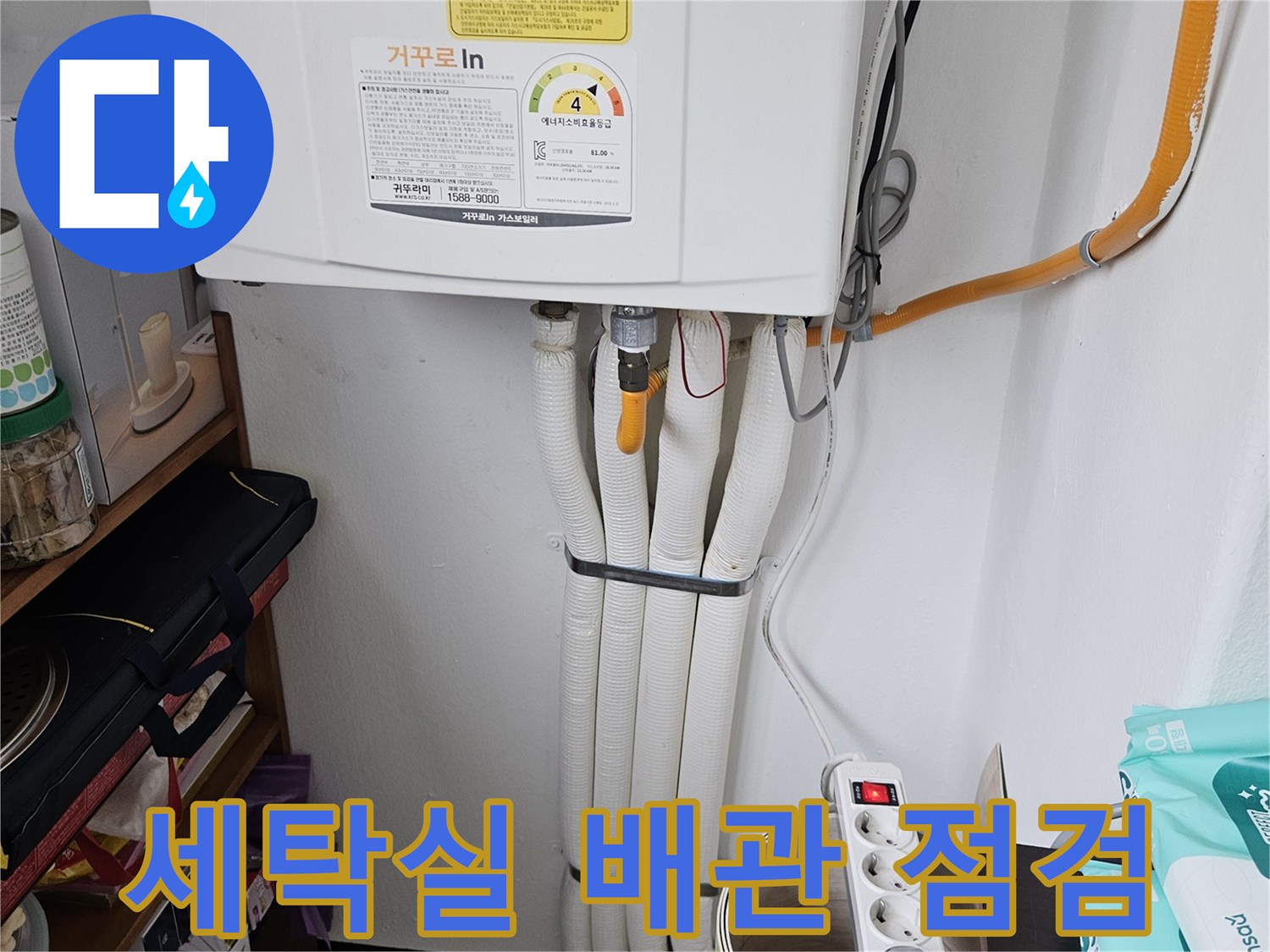 세탁실 벽면의 하얀색 배관과 노란색 호스가 연결된 모습입니다.