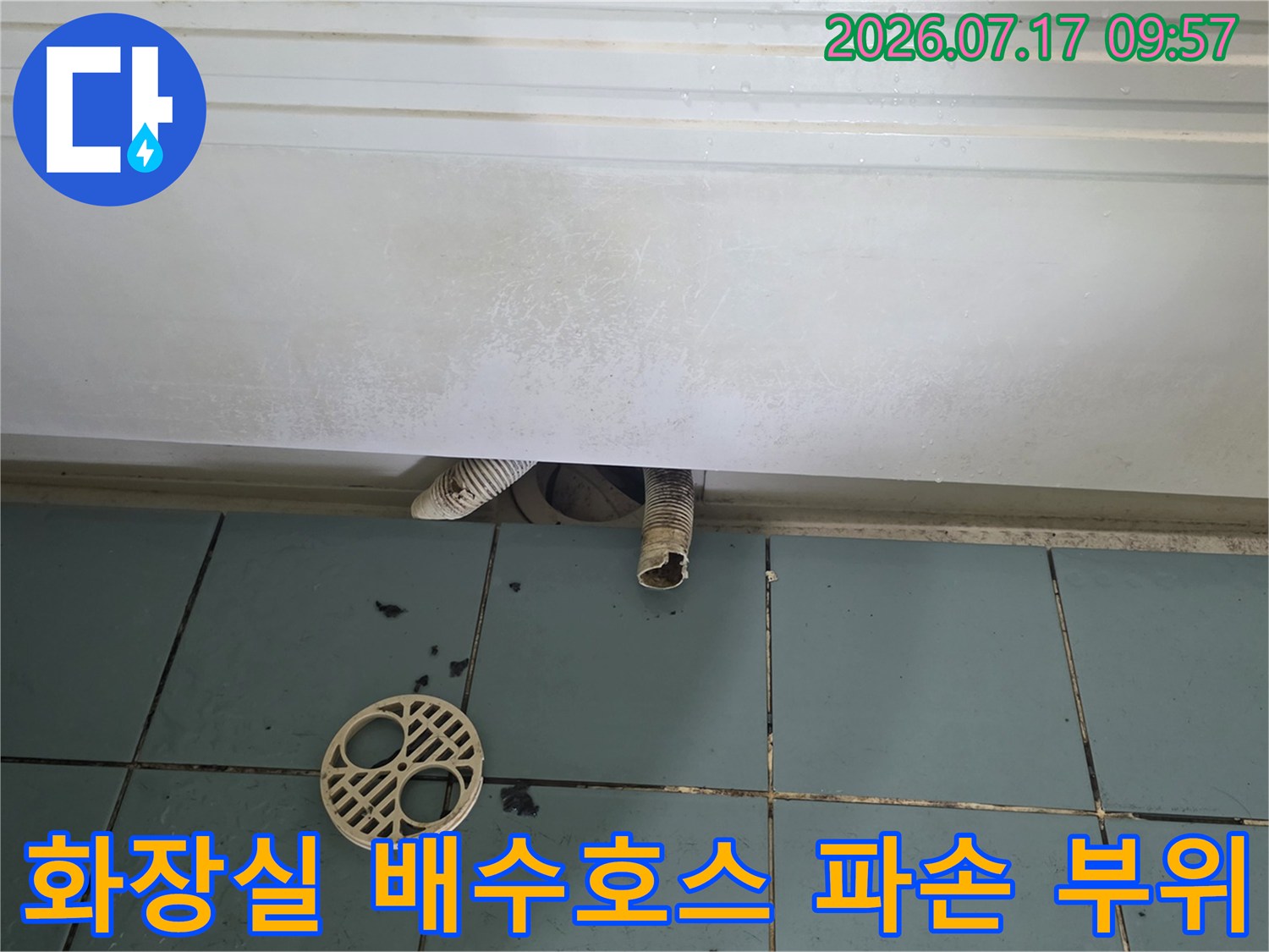 파손된 화장실 배수 호스와 주변의 노출된 배관 상태