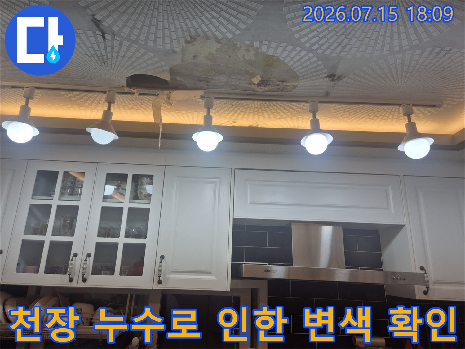 오염된 주방 천장 마감재와 조명 아래 배관 상태를 점검하는 현장 사진