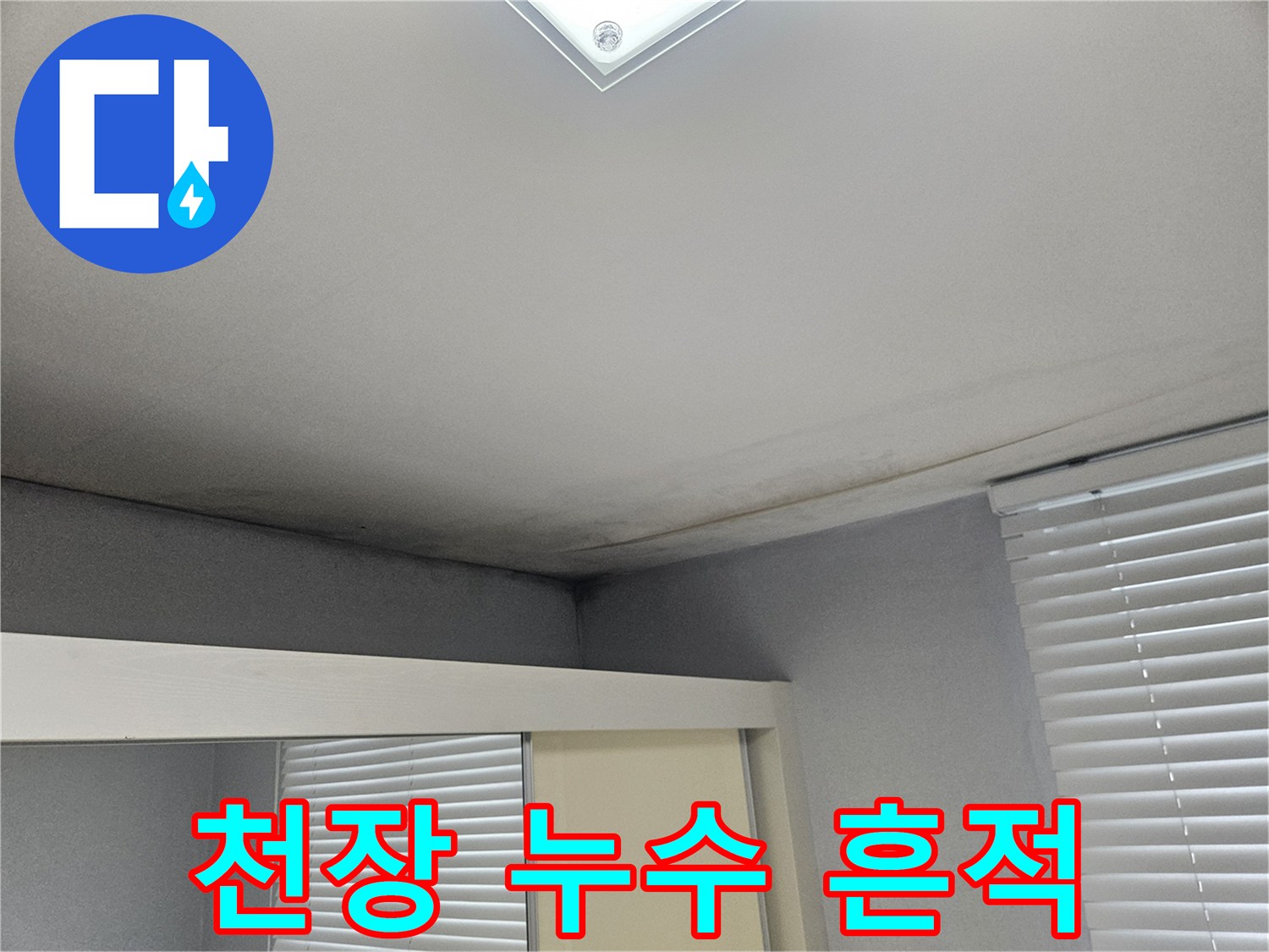거실 천장 구석의 어두운 누수 자국