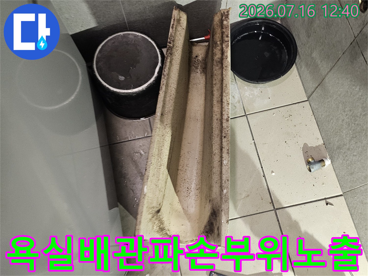 거친 콘크리트 벽면이 파헤쳐진 상태에서 노출된 배관 부분의 모습