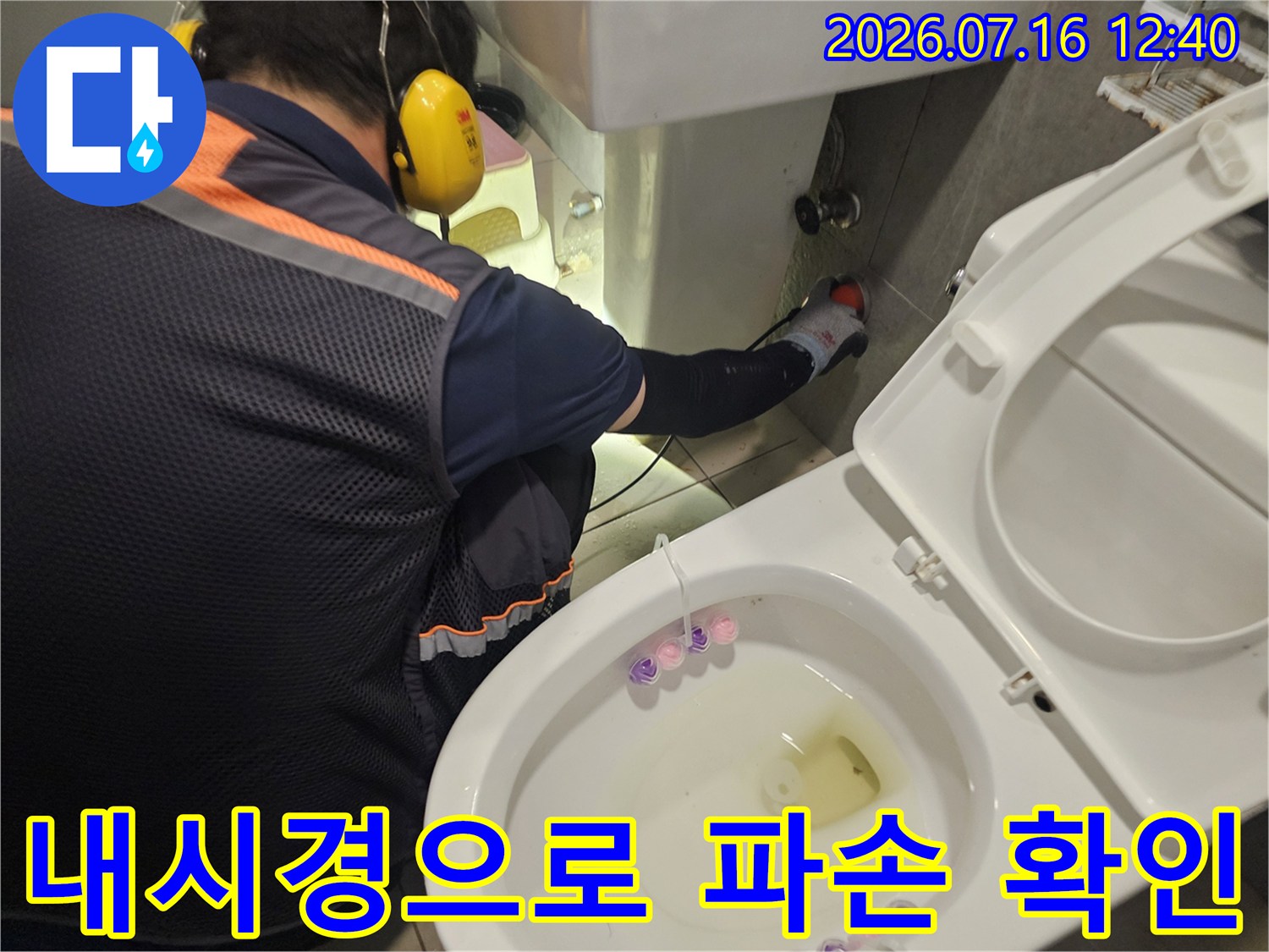 전문가가 장비를 사용하여 배관 내부를 실시간 점검하는 모습