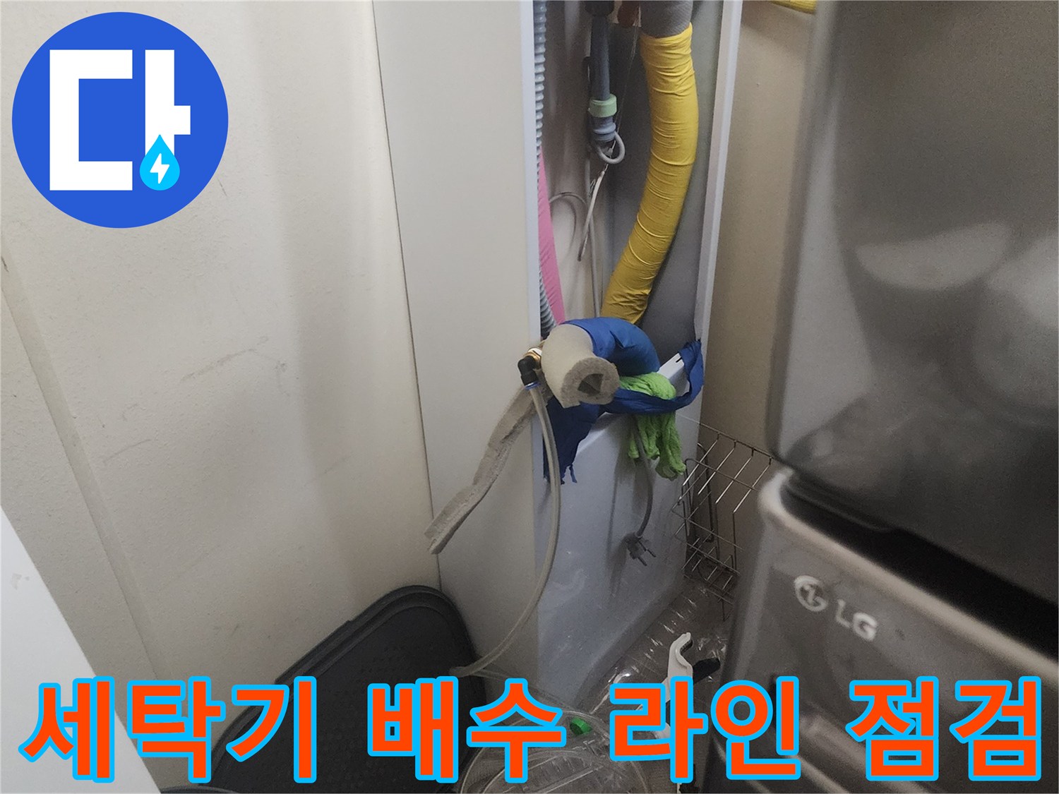 세탁기 뒤편의 좁은 공간에 설치된 배수 호스와 배관 모습