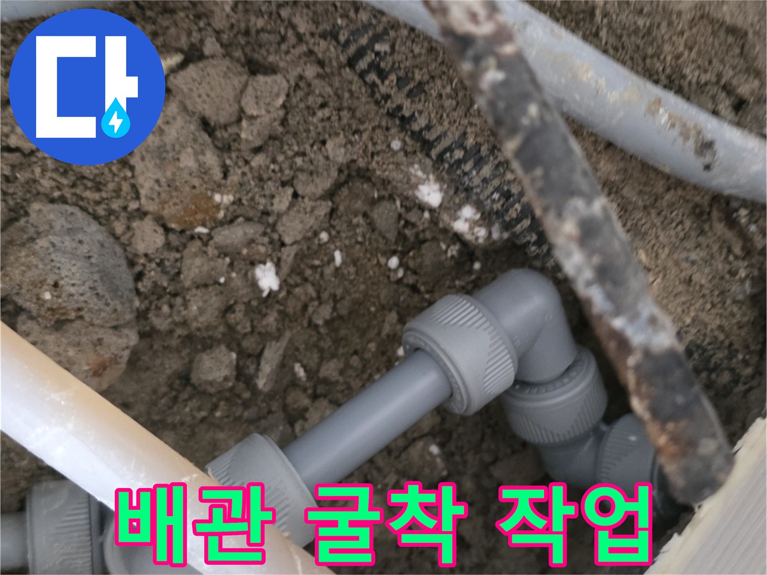 콘크리트 아래 노출된 회색 난방용 파이프 연결 부위
