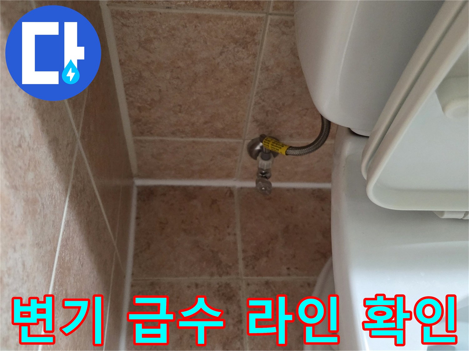 베이지색 욕실 타일과 변기 뒤쪽의 금속제 급수 밸브 사진