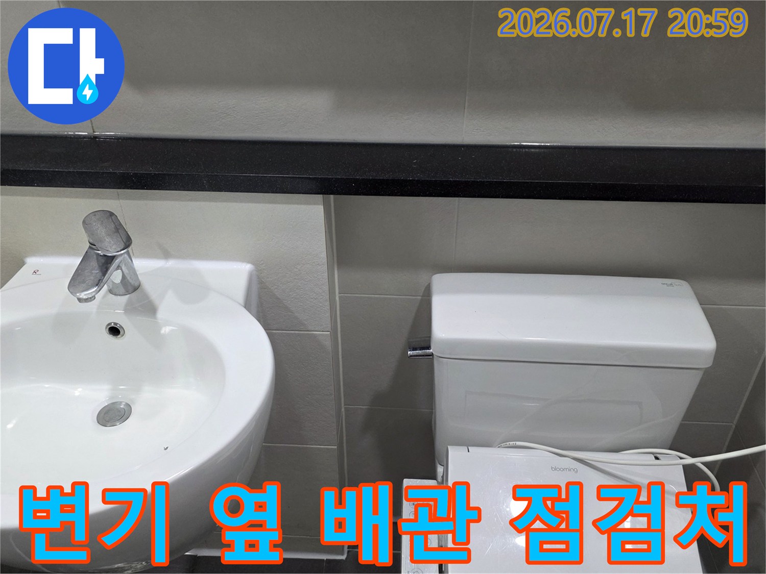 세면대와 변신 사이의 공간에 위치한 화장실 내 배출 시설물