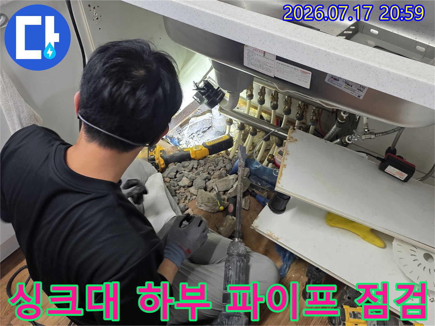 싱크대 아래 공간에서 배관의 연결 상태와 노후도를 진찰하는 모습