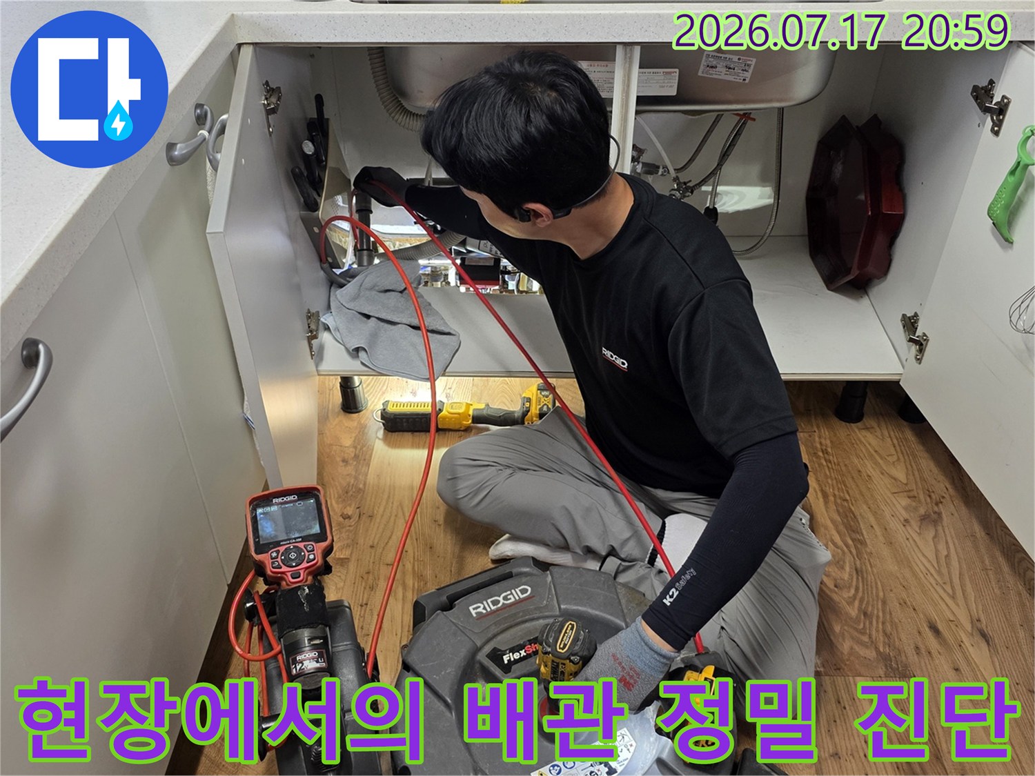 싱크대 하부 공간 내 장비를 이용하여 배출 경로를 점검하는 장면