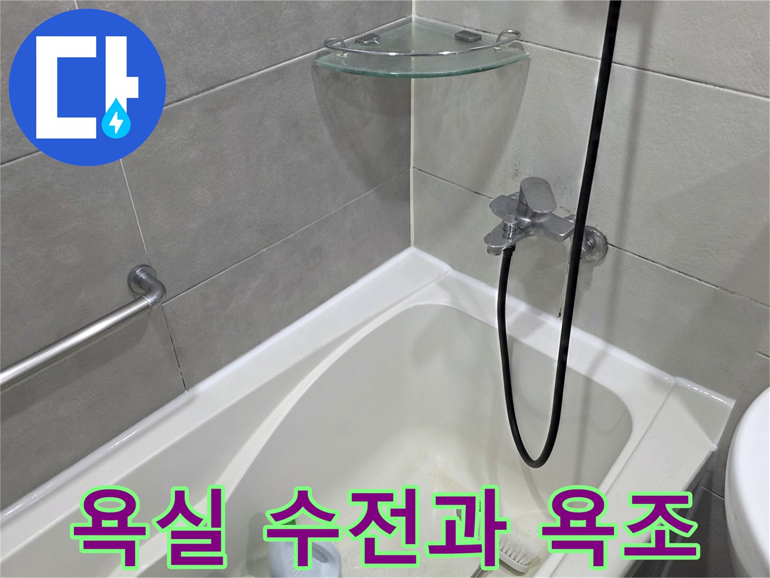 욕실 벽면에 설치된 샤워 수전과 하얀색 욕조의 모습입니다.