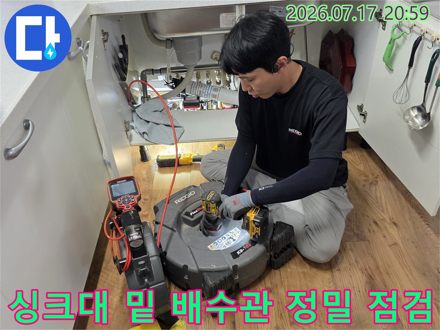 전문 장비를 사용하여 싱크대 하부 배수관을 정밀하게 탐지하는 모습