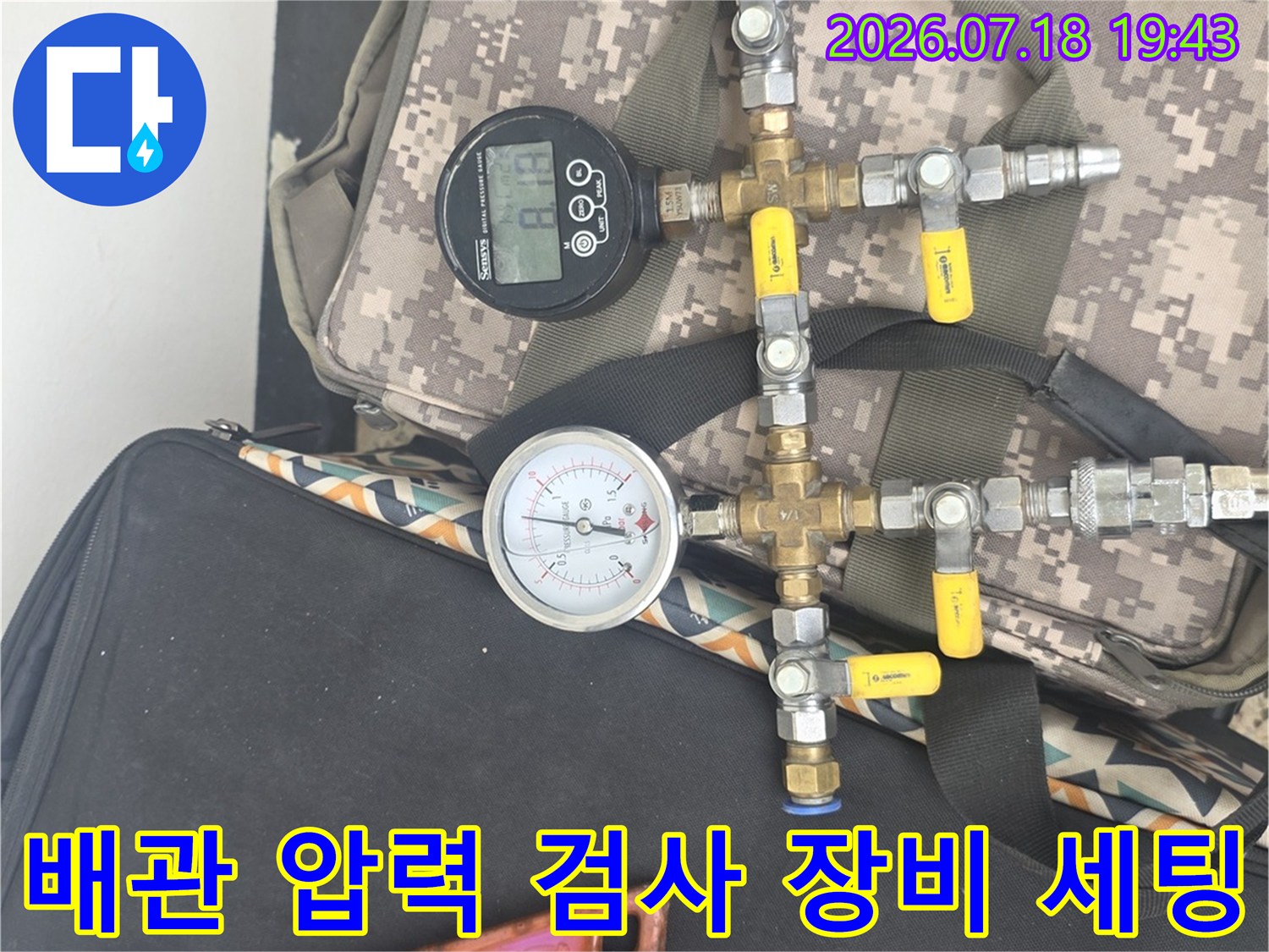 디지털 게이지와 아날로그 압력계가 연결된 배관 점검 장비