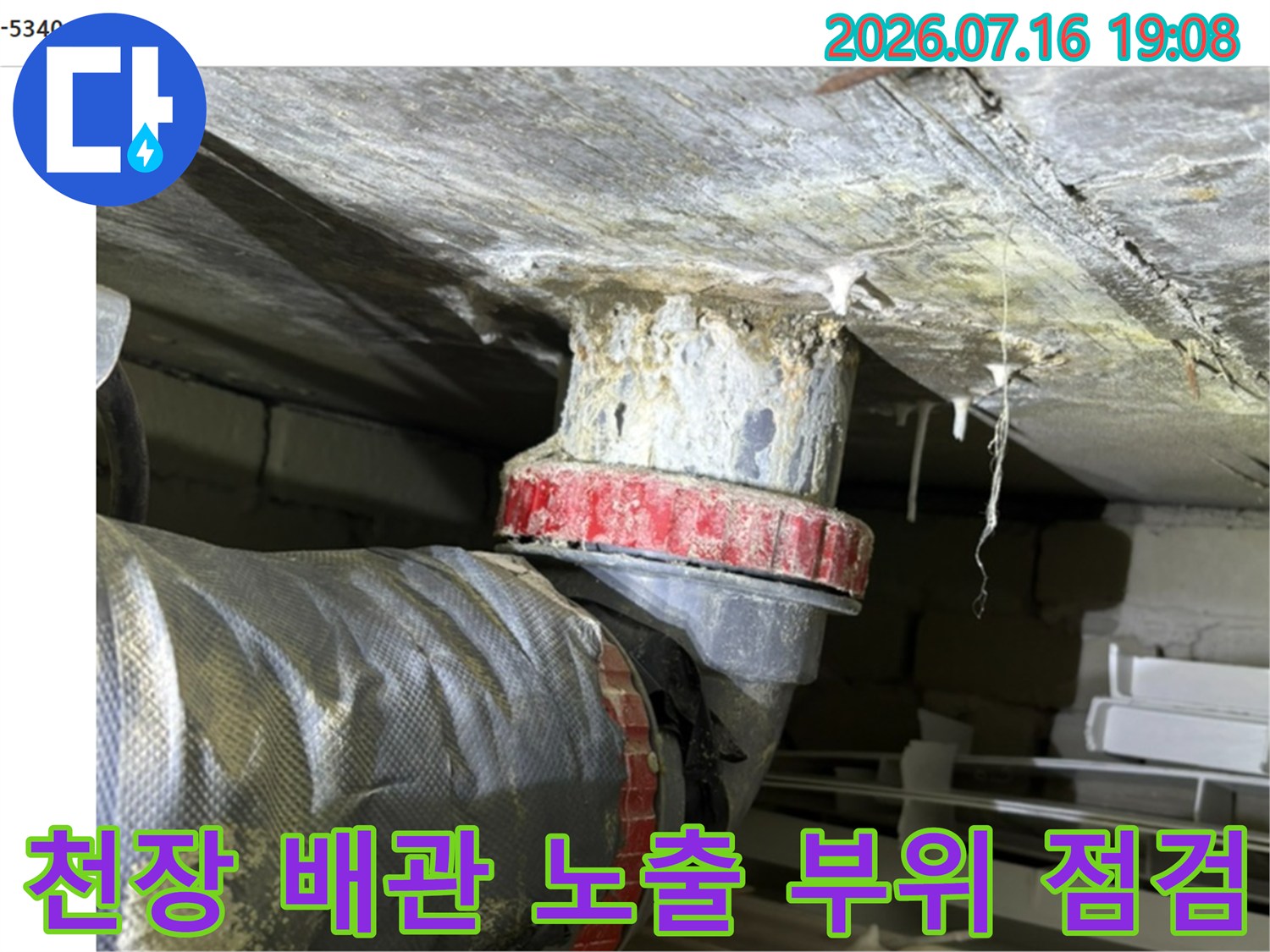 배관 연결부의 누수 여부를 확인하기 위해 천장 안쪽을 정밀하게 살피는 모습