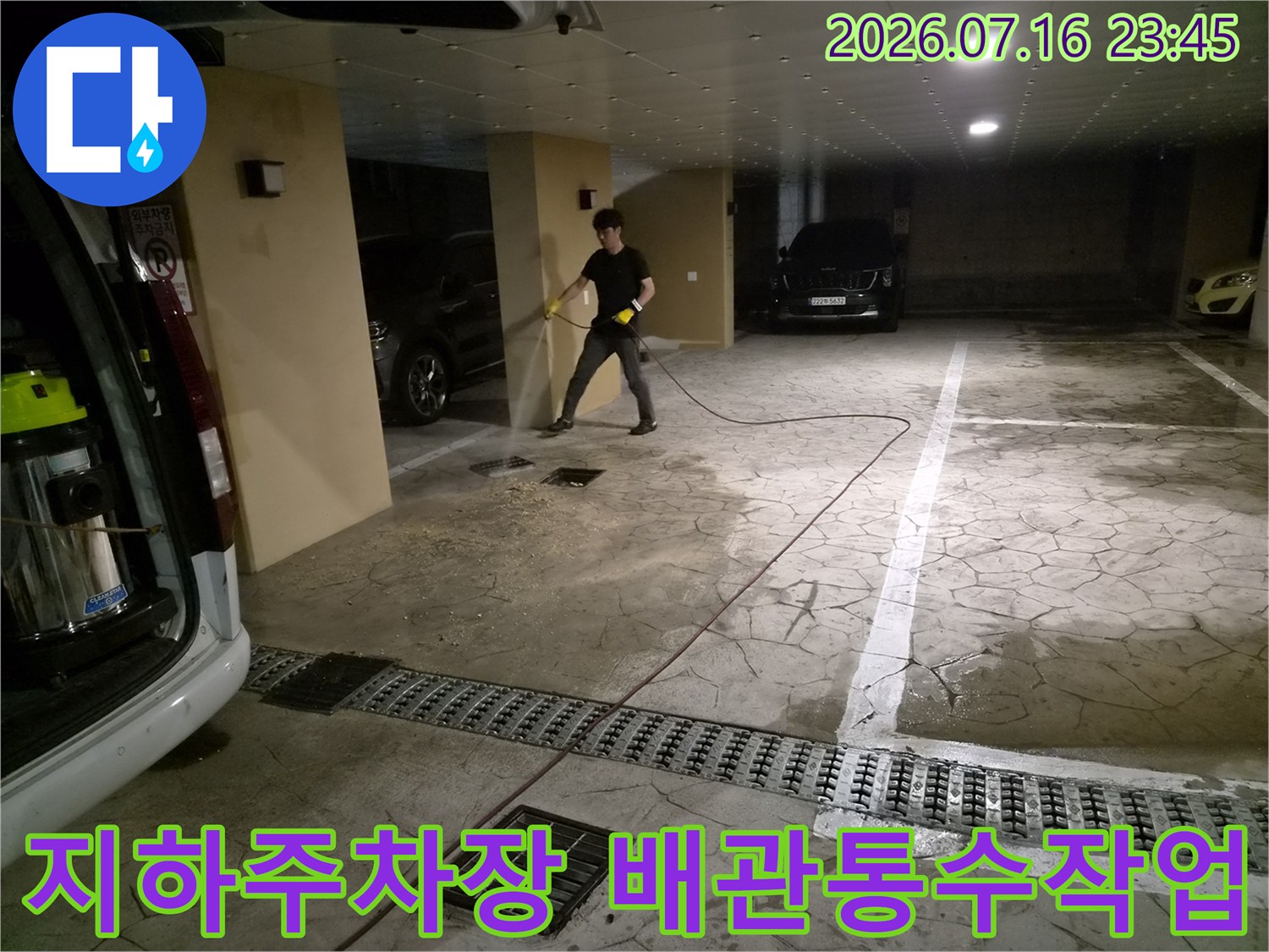 지하주차장 바닥에서 전문 장비로 공용 배관 통수 작업을 진행하는 모습