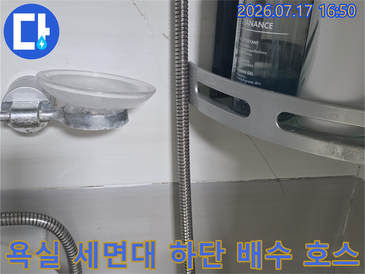 세면대 아래에 설치된-은색 금속재질의 유연한 주름관 파이프