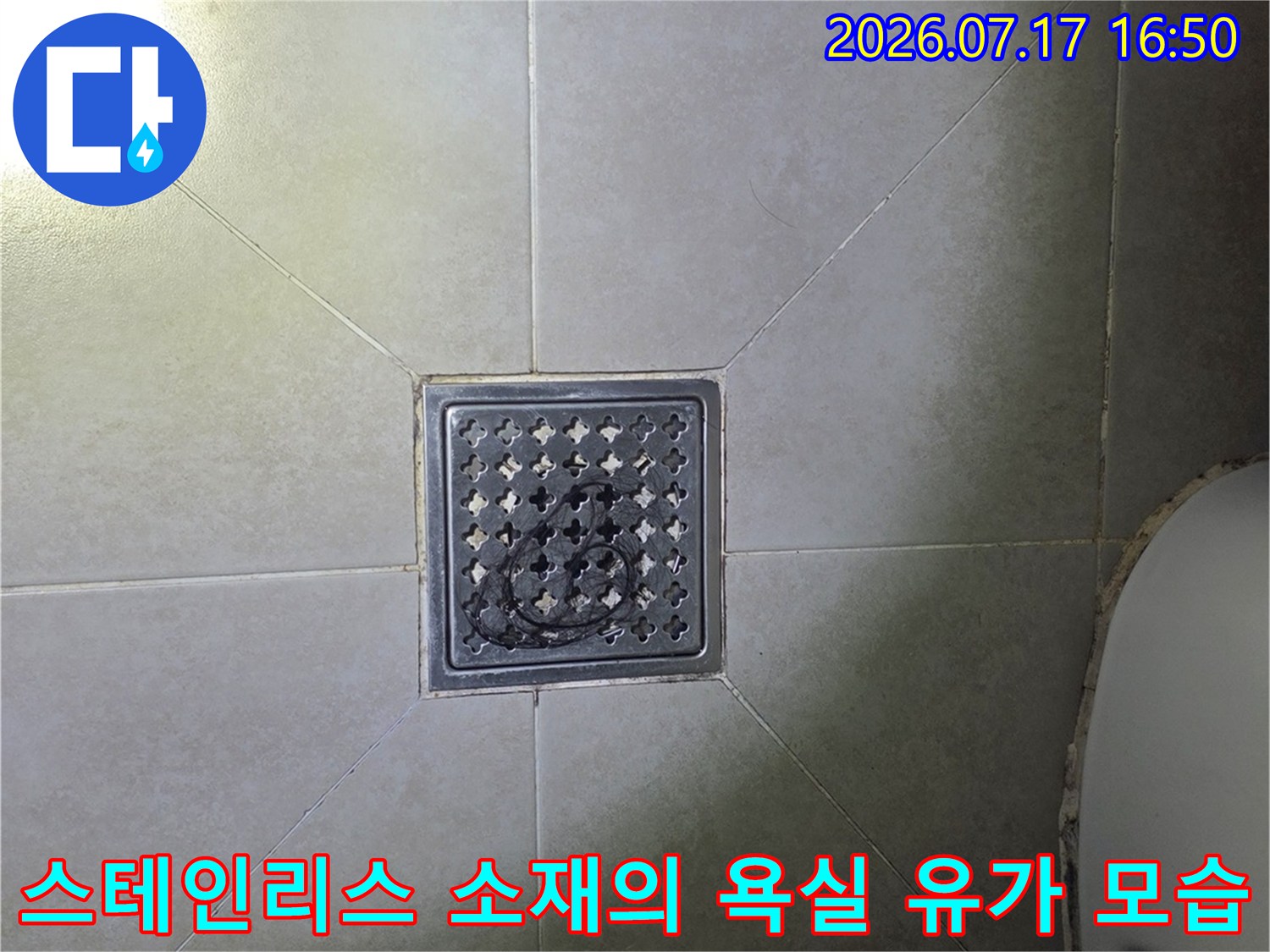 화장실 바닥 중앙에 위치한 금속제 배수구 덮개-클로즈업 사진