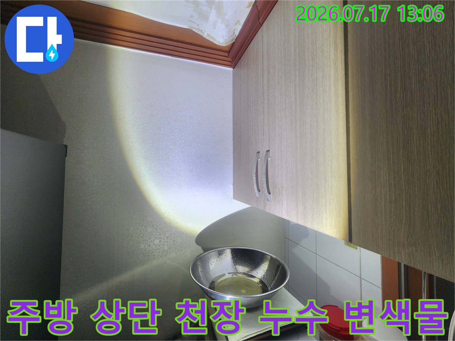 싱크대 수납장 위쪽 천장에 발생한 노란색 누수 얼룩-사진