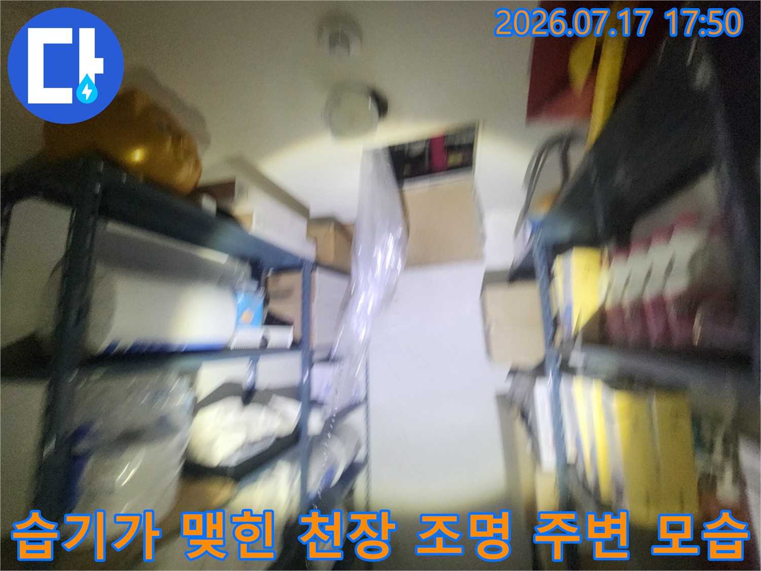 창고 내부-천장의 조명 기구와 배관 연결부 사진