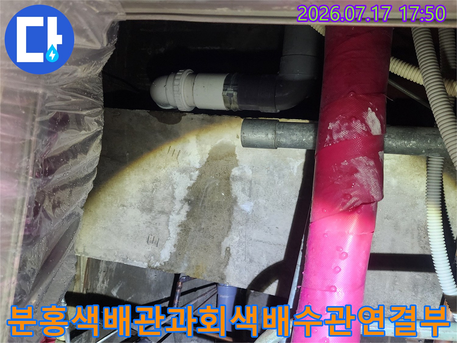천장 속 분홍색 보온재 배관 하단에 위치한 회색 PVC 배수관 연결 부위의 상세 모습
