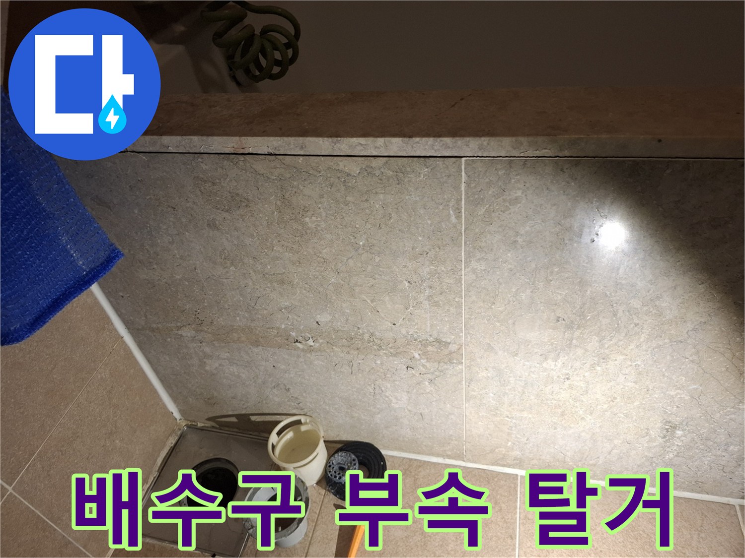 욕실 바닥 배수구 주변의 노후된 방수 상태를 점검하는 장면입니다.