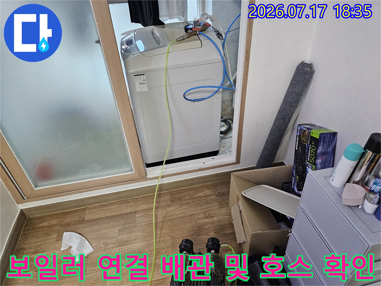흰색 보일러 위에 설치된 파란색-노란색 수도 배관 라인-근접 촬영
