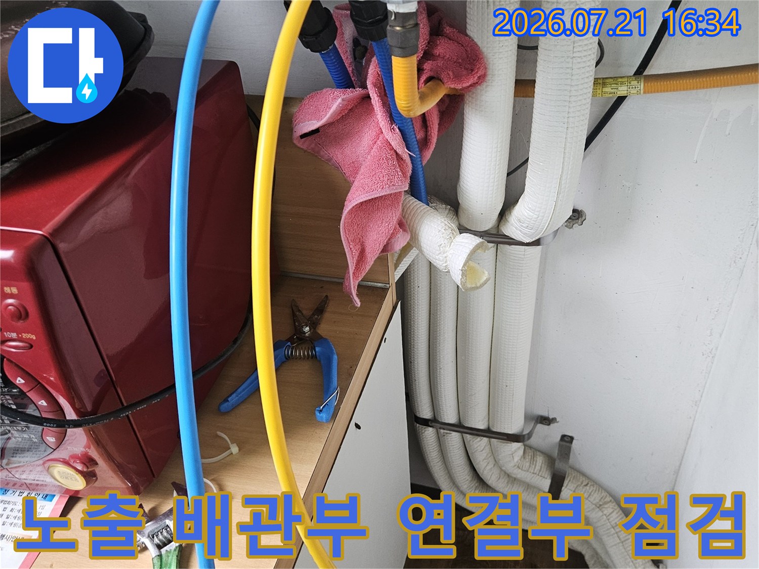 상수 및 온수 배관의 밸브와 파이프 연결 부위를 세밀하게 조사하는 모습
