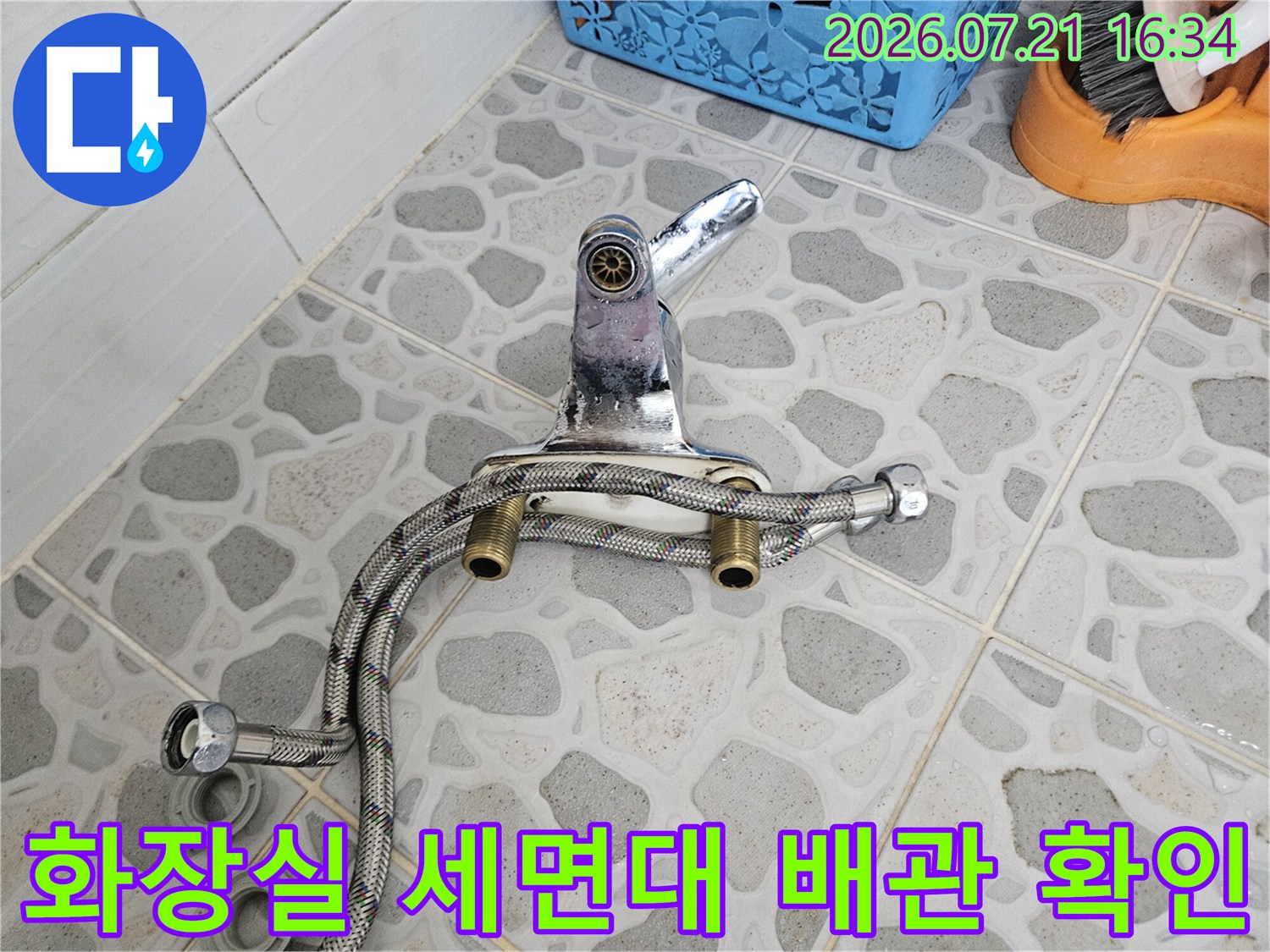 세면대 아래 위치한 은색 굴곡형 배관과 수도 연결 부위의 누수 여부를 점검하는 현장 모습