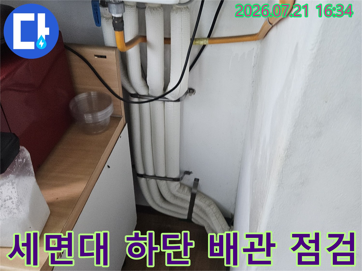 세면대 아래쪽으로 복잡하게 얽힌 수도 배관과 노출된 연결 부위 점검