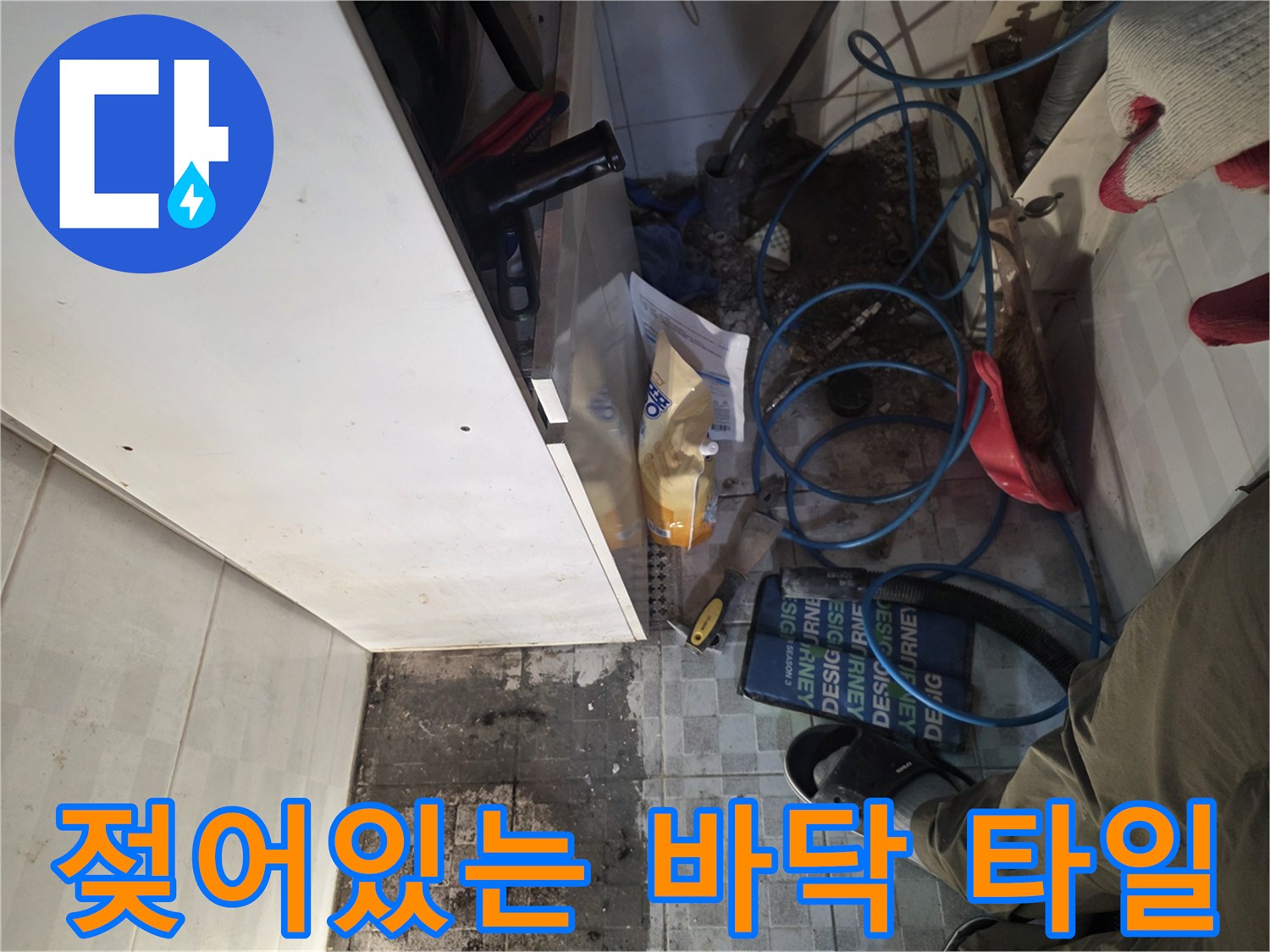 오정구 작업 현장-싱크대 아래 젖은 타일과 주변 정리 상태