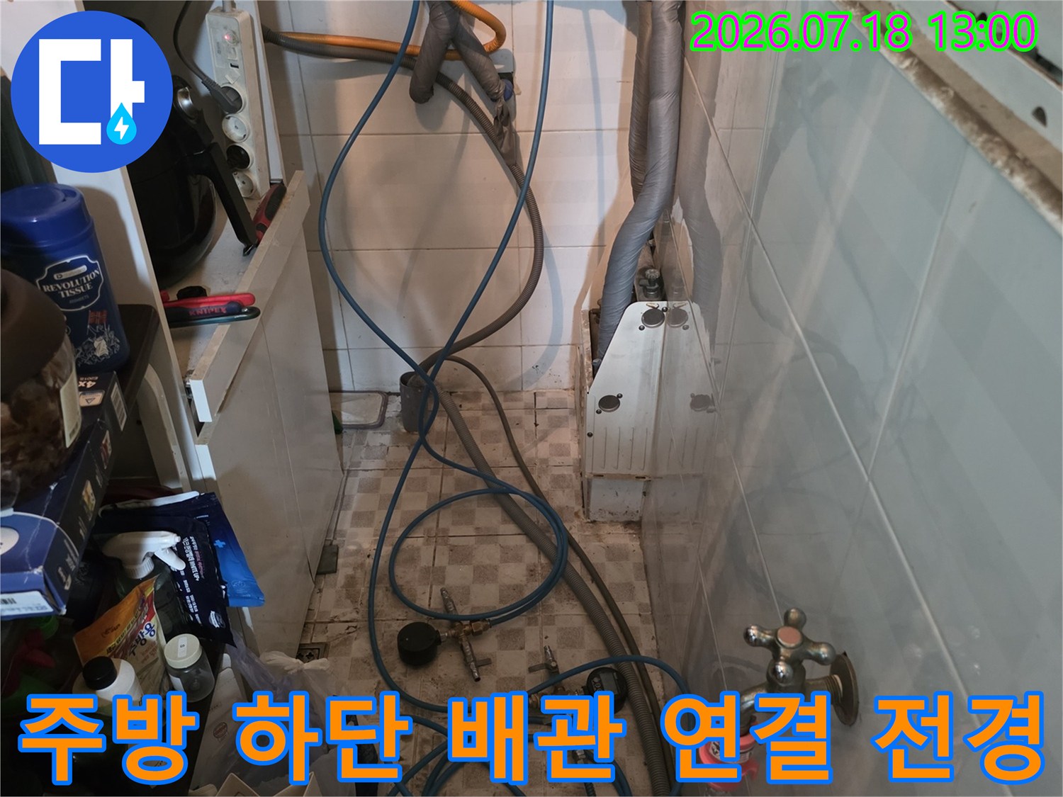 흰색 타일 벽면에-설치된 수도 밸브와 복잡한 파란색 배관망 모습