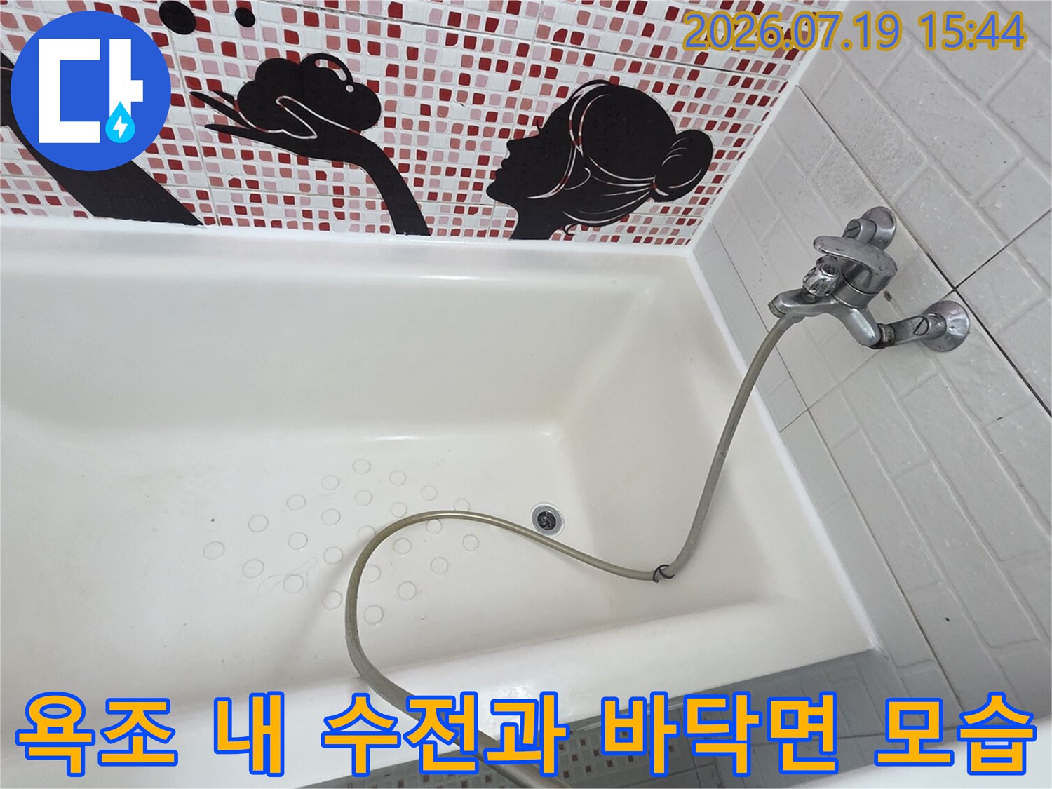 벽면에 고정된 은색 수도꼭지와 욕조 중앙의 원형 배수구가 보이는 내부 전경