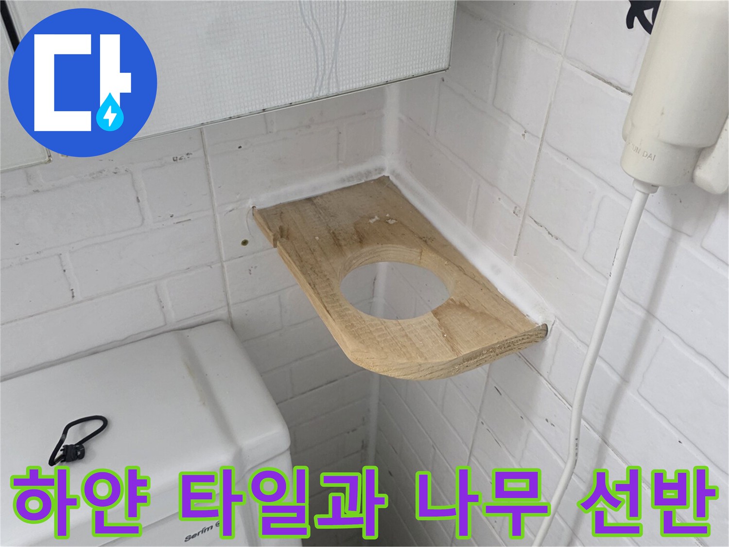 변기 옆 벽면의 하얀색 타일과 목재 선반