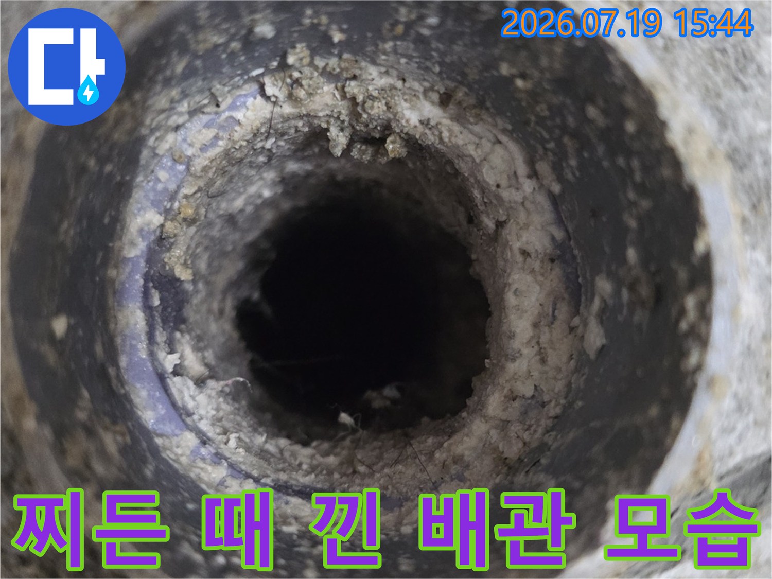콘크리트 마감면에-이물질과 물때가 묻은-원형 하수구 파이프 사진