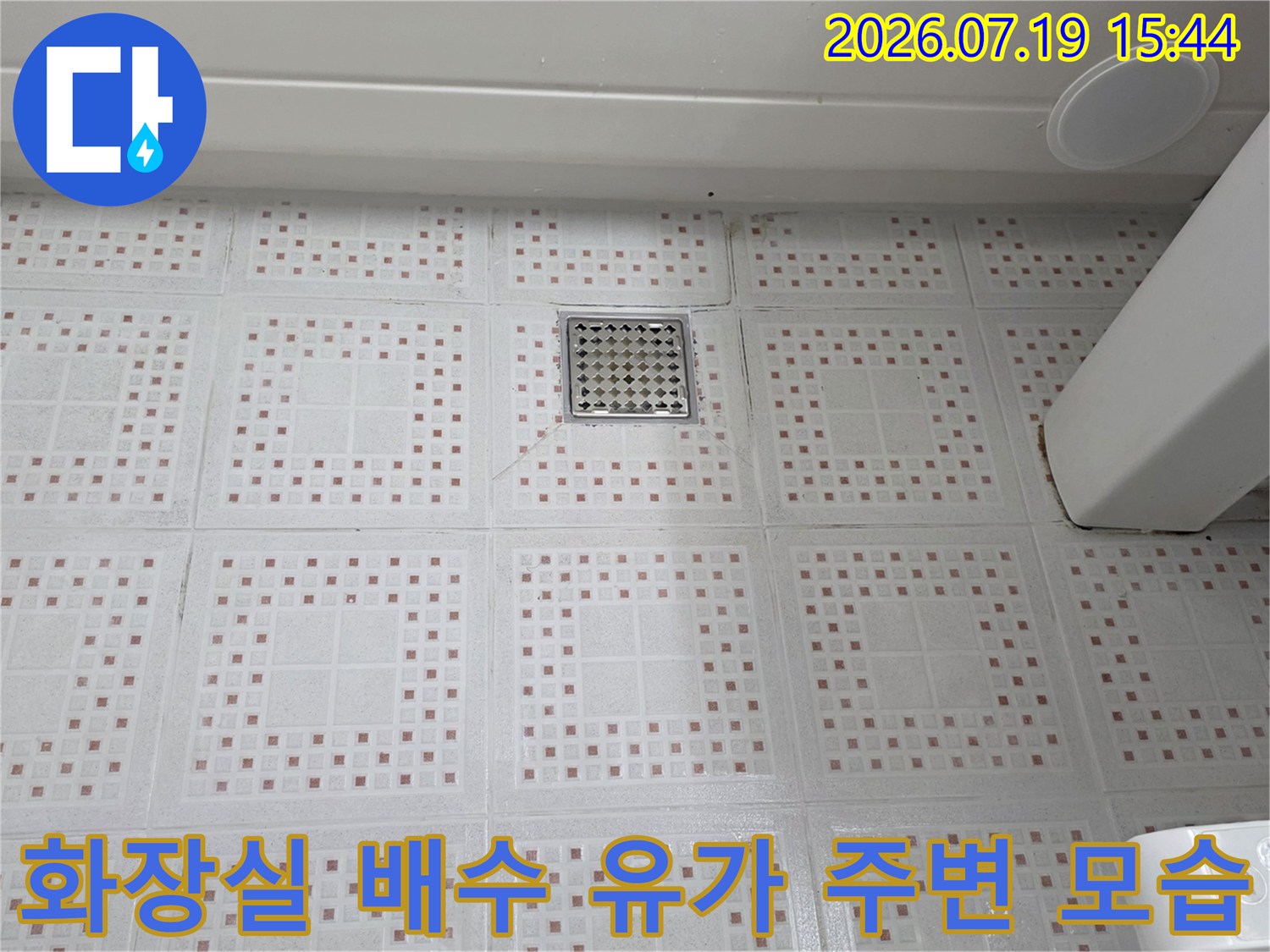 패턴이-있는-화이트-타일-바닥과-중앙의-배수구