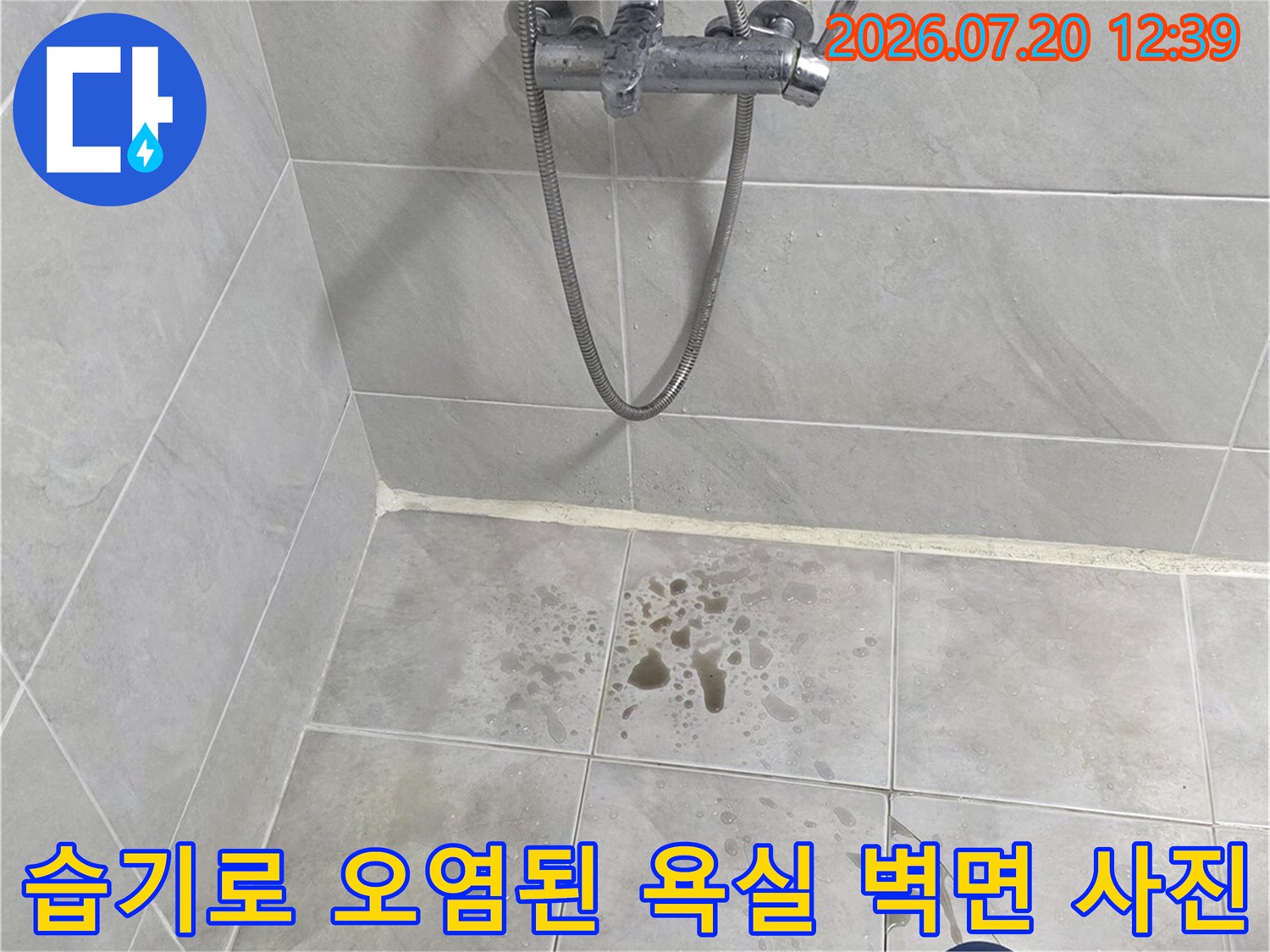 샤워 수전 우측 타일 벽면에 넓게 퍼진 갈색의 누수 흔적 모습