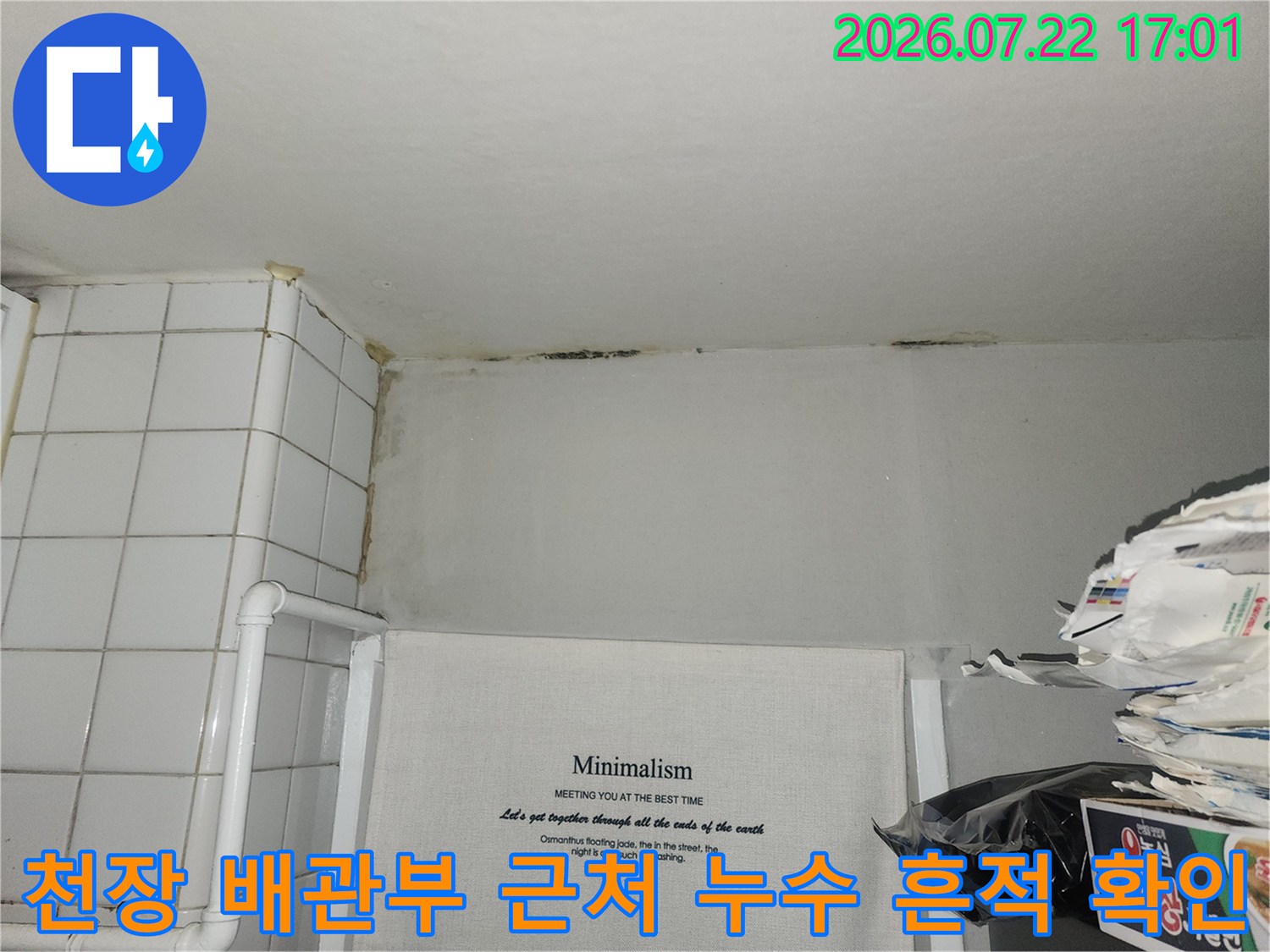 배관이 노출된 천장 부위에 발생한 수분 얼룩과 오염을 점검하는 장면
