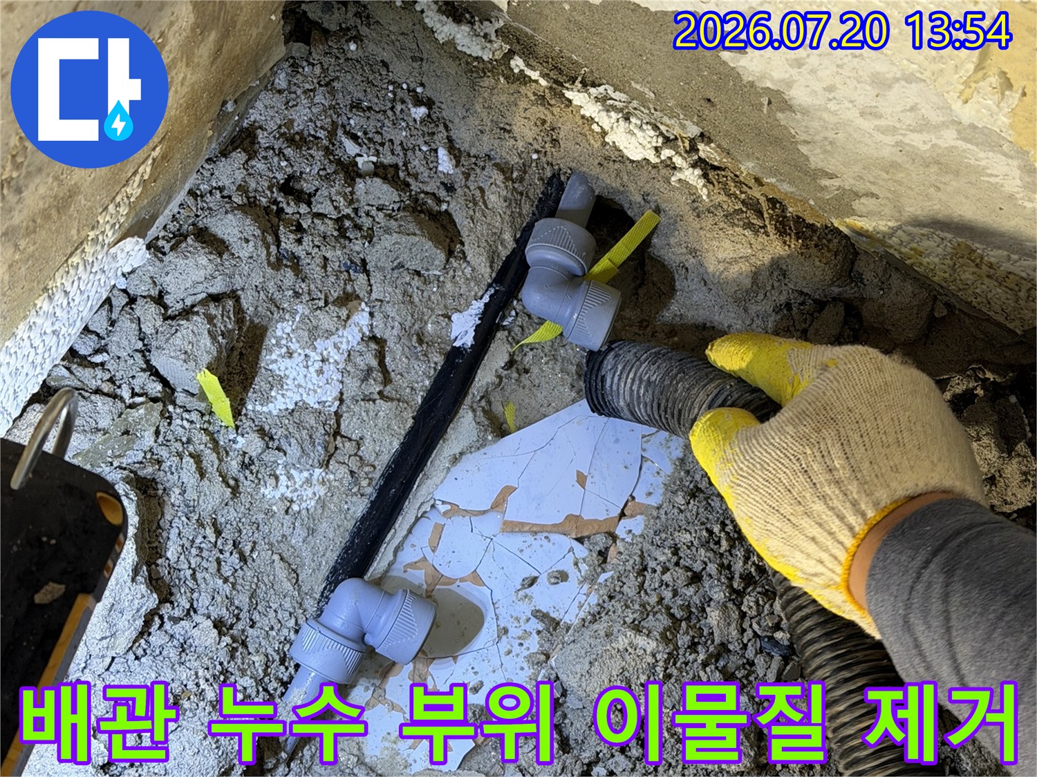 파손되어-물이-새고-있는-검정색-배관-엘보-주변을-흡입기로-청소하는-현장-사진